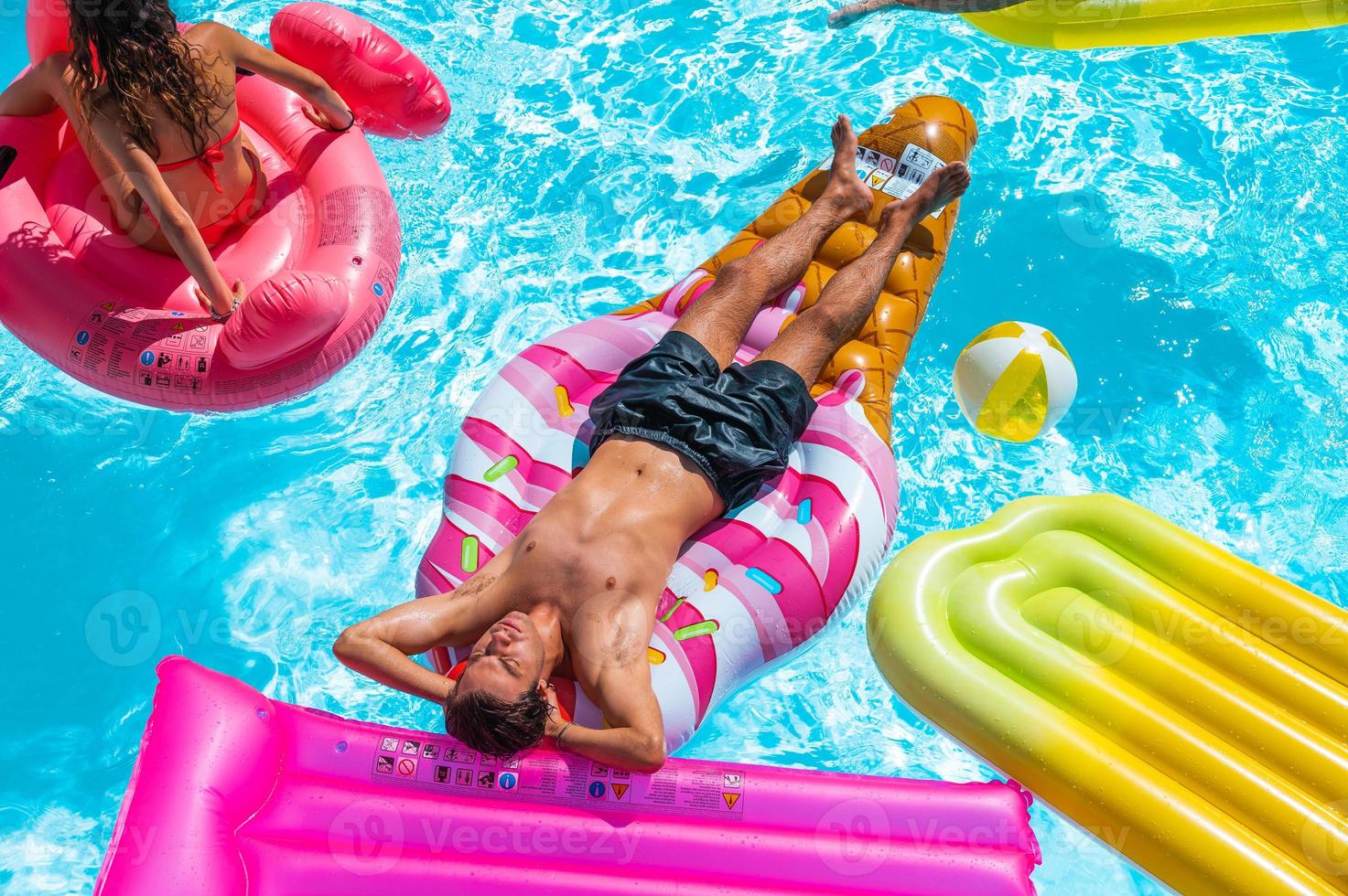 Friends in swimsuit in the pool getting a tan photo
