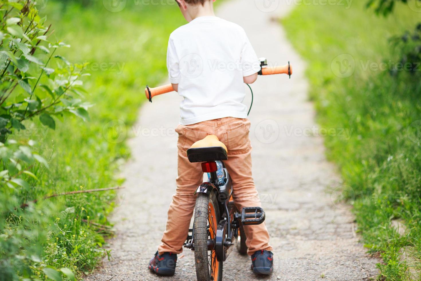 Boy with a bicycle on the street photo
