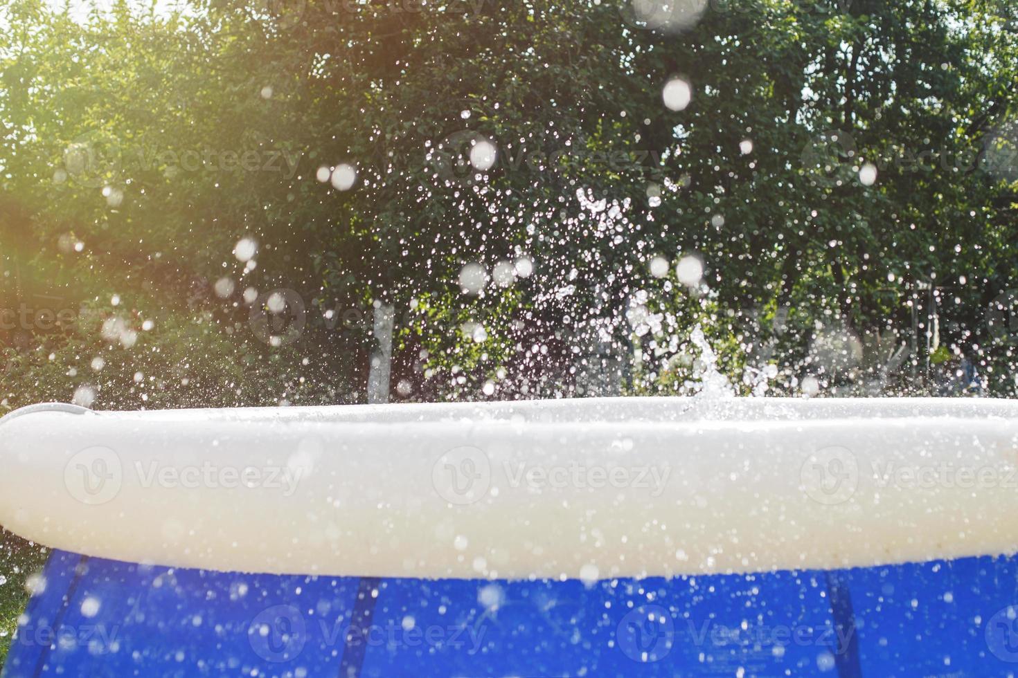Splash of water in the swimming pool from kid jump. water splash background. photo