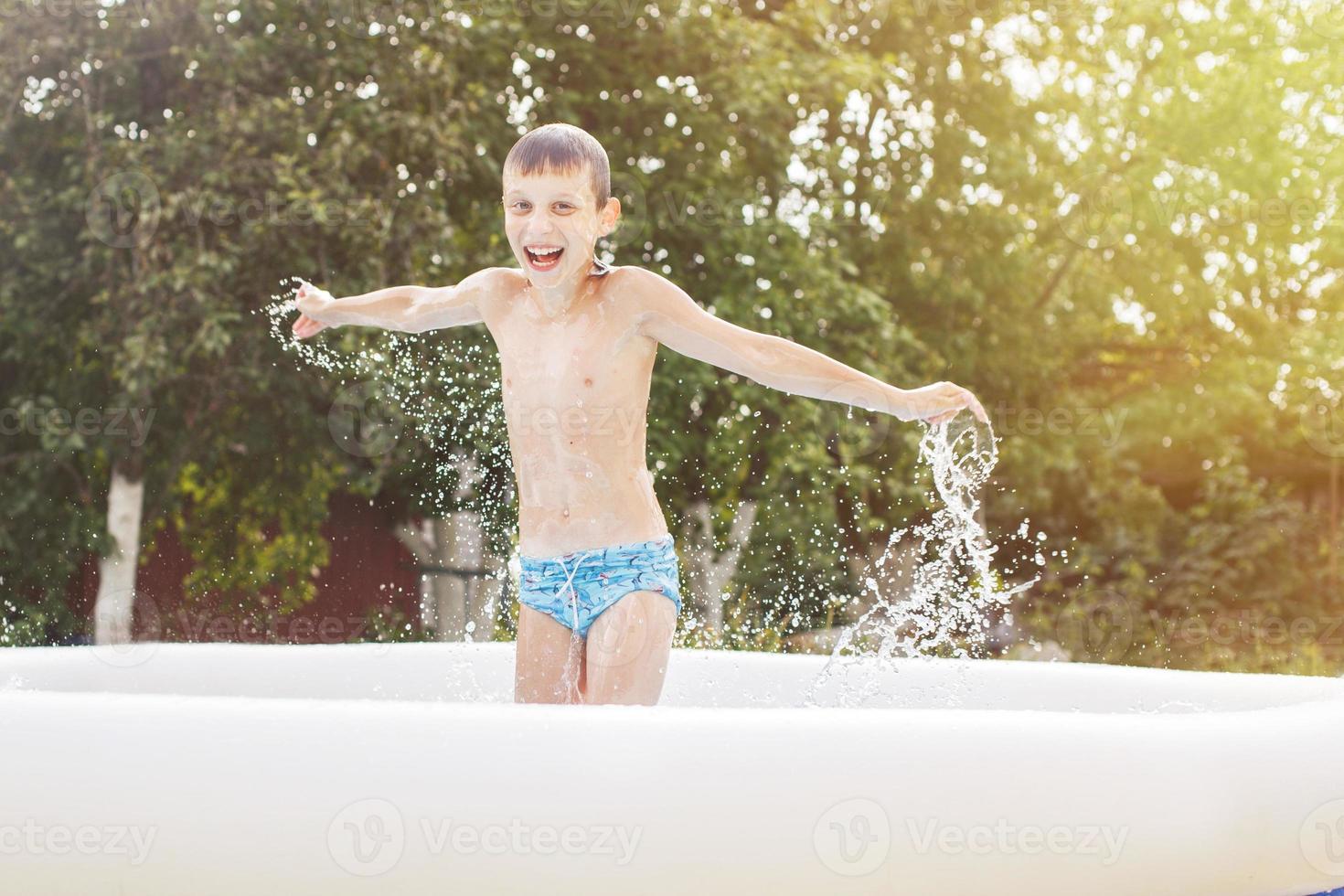 contento chico teniendo divertido en el nadando piscina con padre en el jardín a verano foto