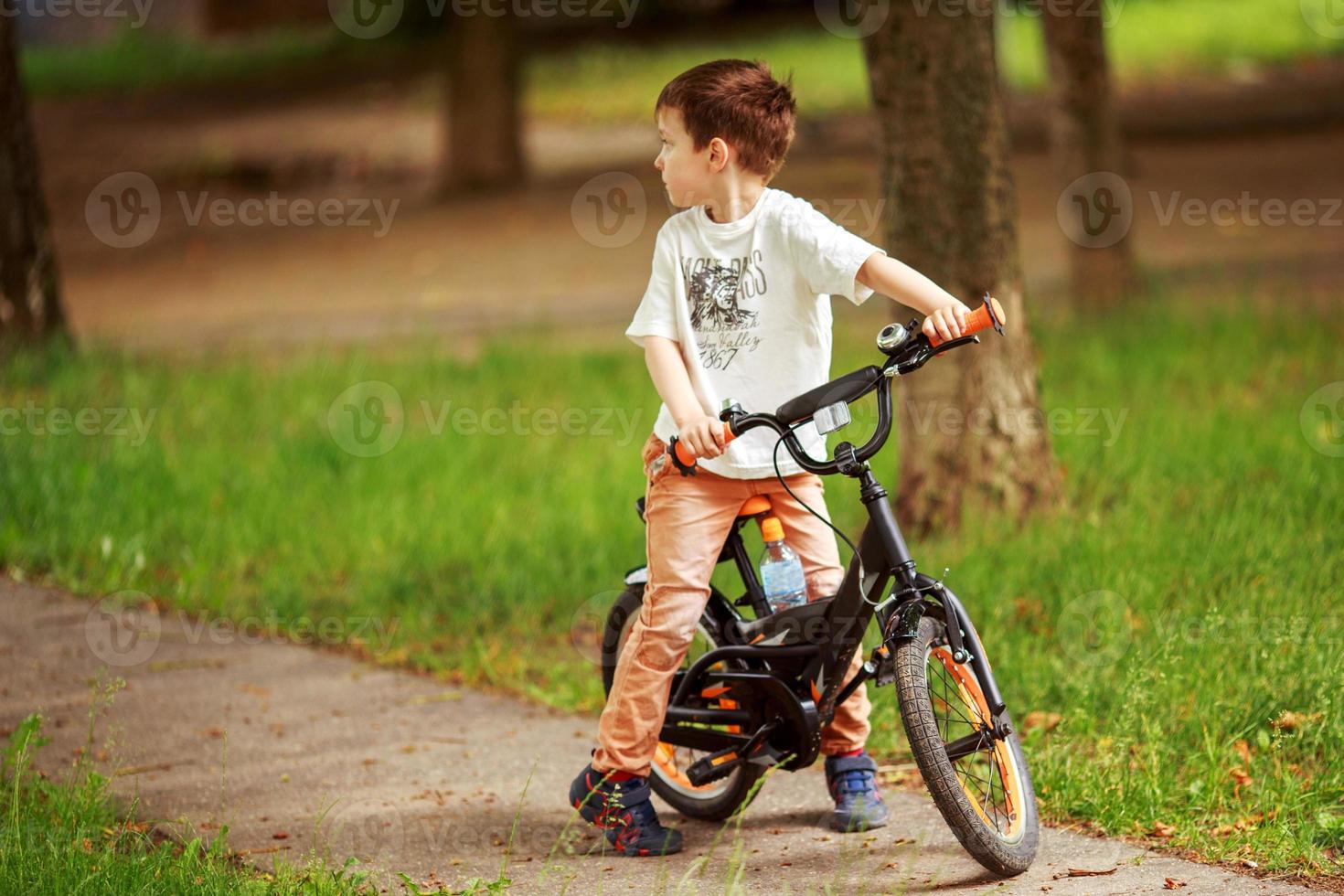 el chico es montando un bicicleta en el calle foto