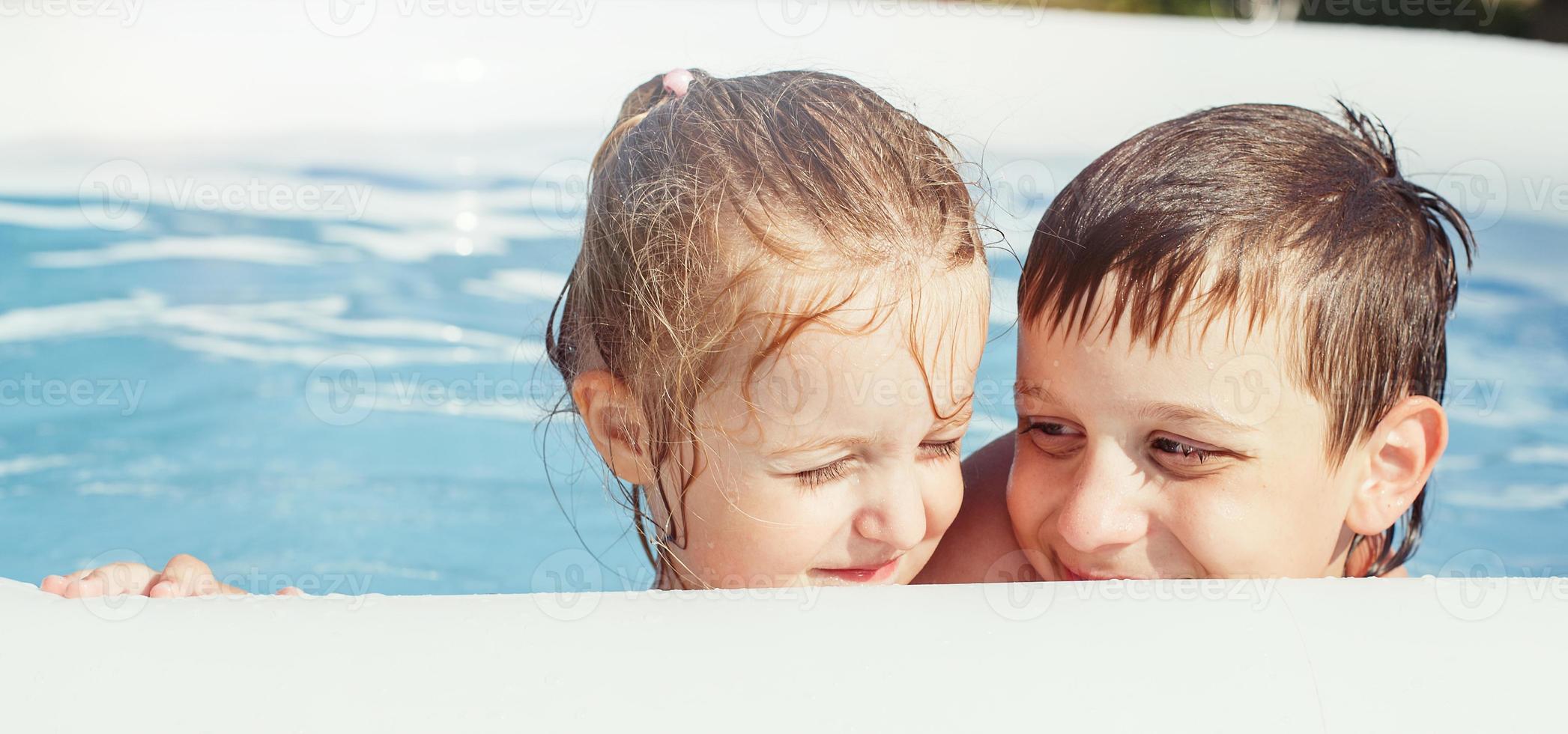 retrato de contento chico y niña en el piscina en el jardín a verano foto