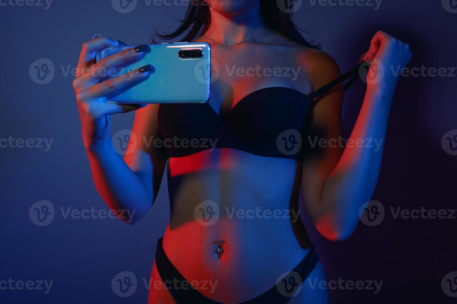 Woman in lingerie take photos with a smartphone