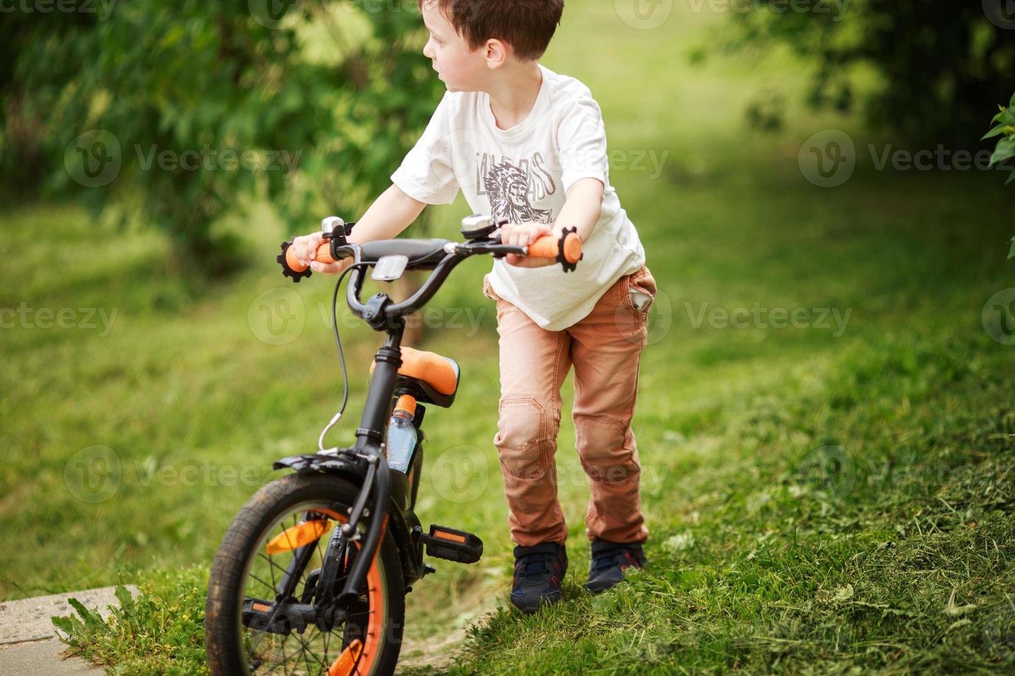 the boy is riding a bike on the street photo