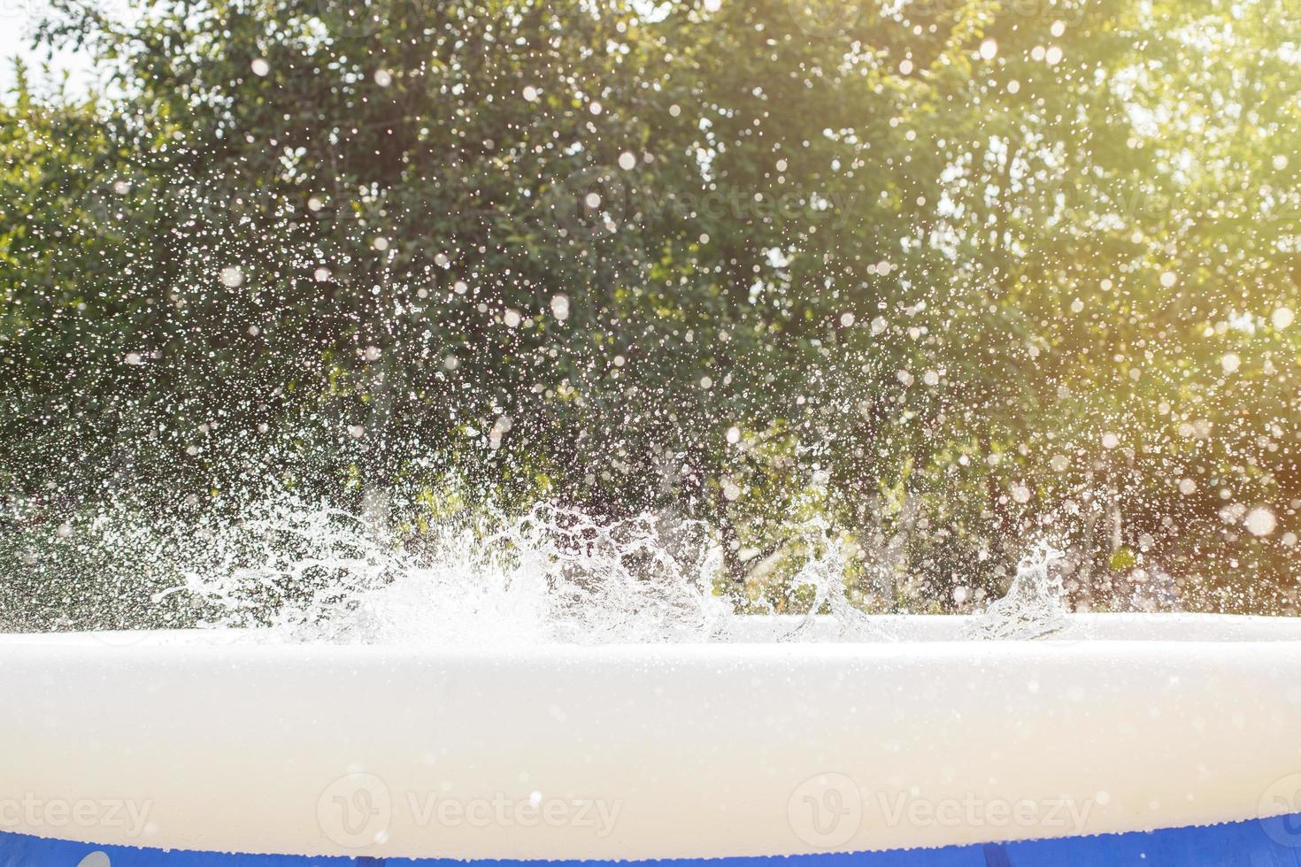 Splash of water in the swimming pool from kid jump. water splash background. photo