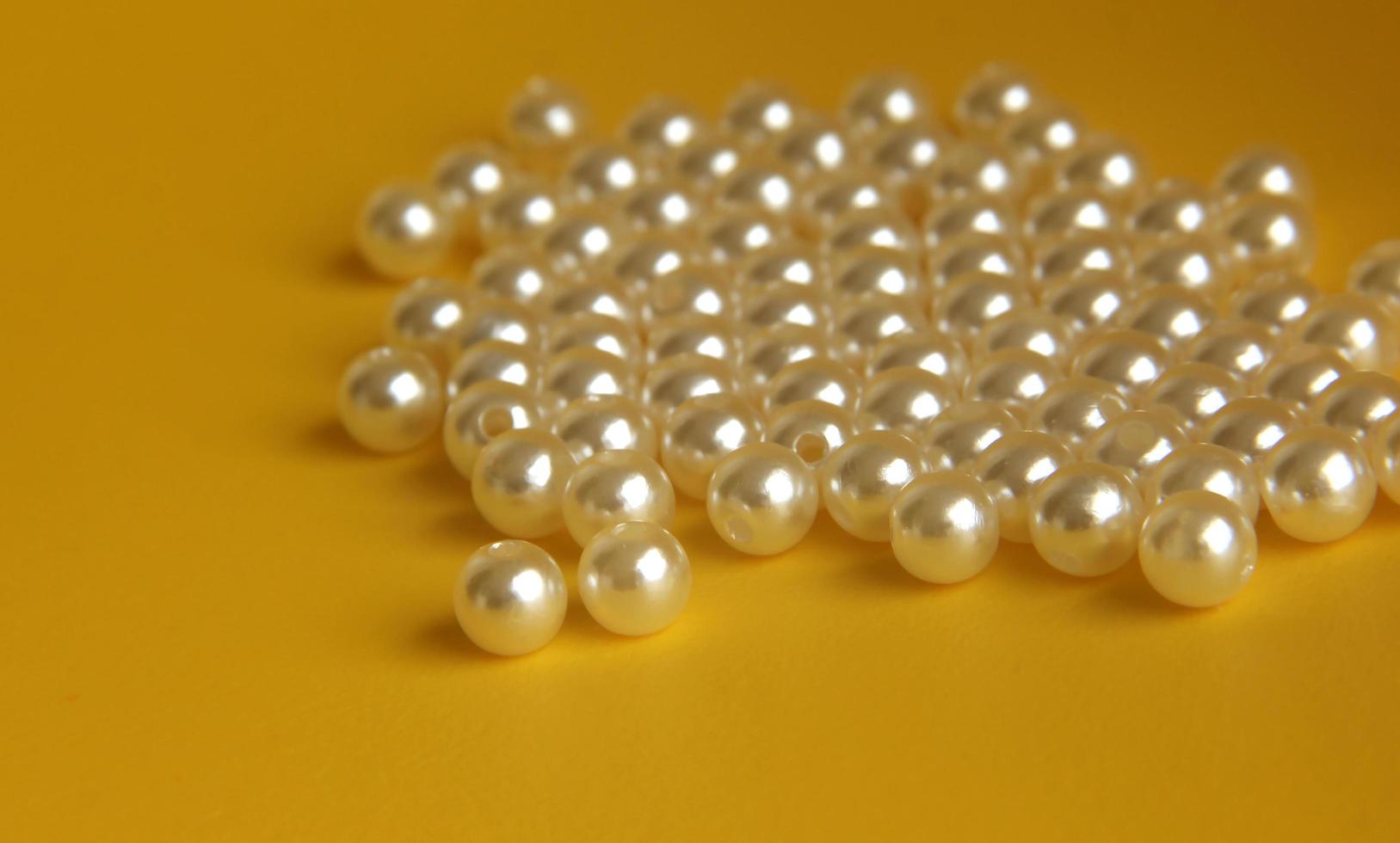 Beautiful white pearl bracelet jewelry beads for fashion or art and craft equipment. Object photo isolated on yellow background.