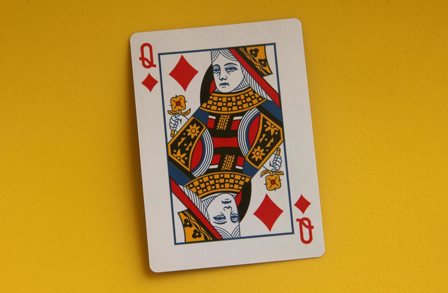 Jakarta, Indonesia - February 24th, 2023 - Queen only. One common playing cards for poker, gambling, or just for fun entertainment purposes. Object photo isolated on yellow background.