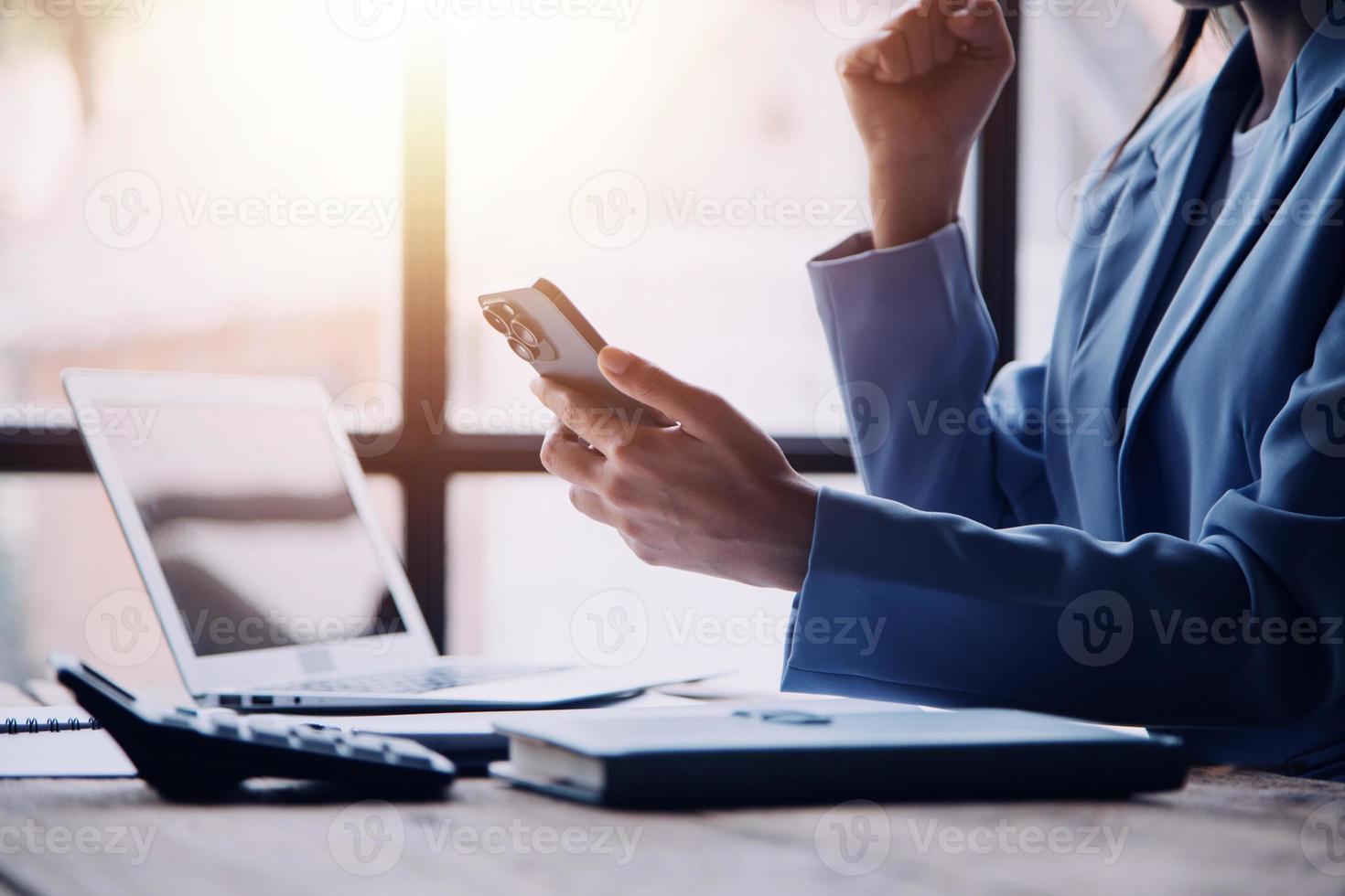 contento emocionado exitoso negocio asiático mujer triunfando en oficina, retrato de un alegre asiático mujer de negocios sentado a el mesa en oficina, foto