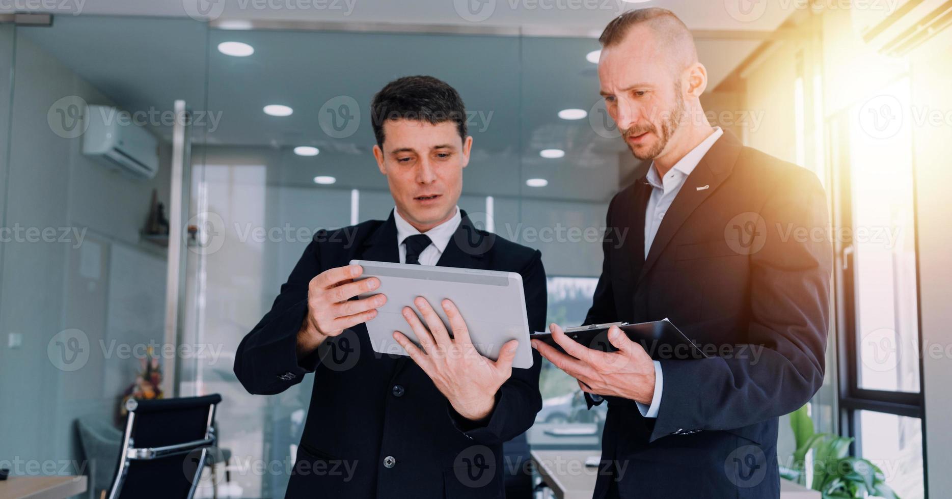 Financial analysts analyze business financial reports on a digital tablet planning investment project during a discussion at a meeting of corporate showing the results of their successful teamwork. photo