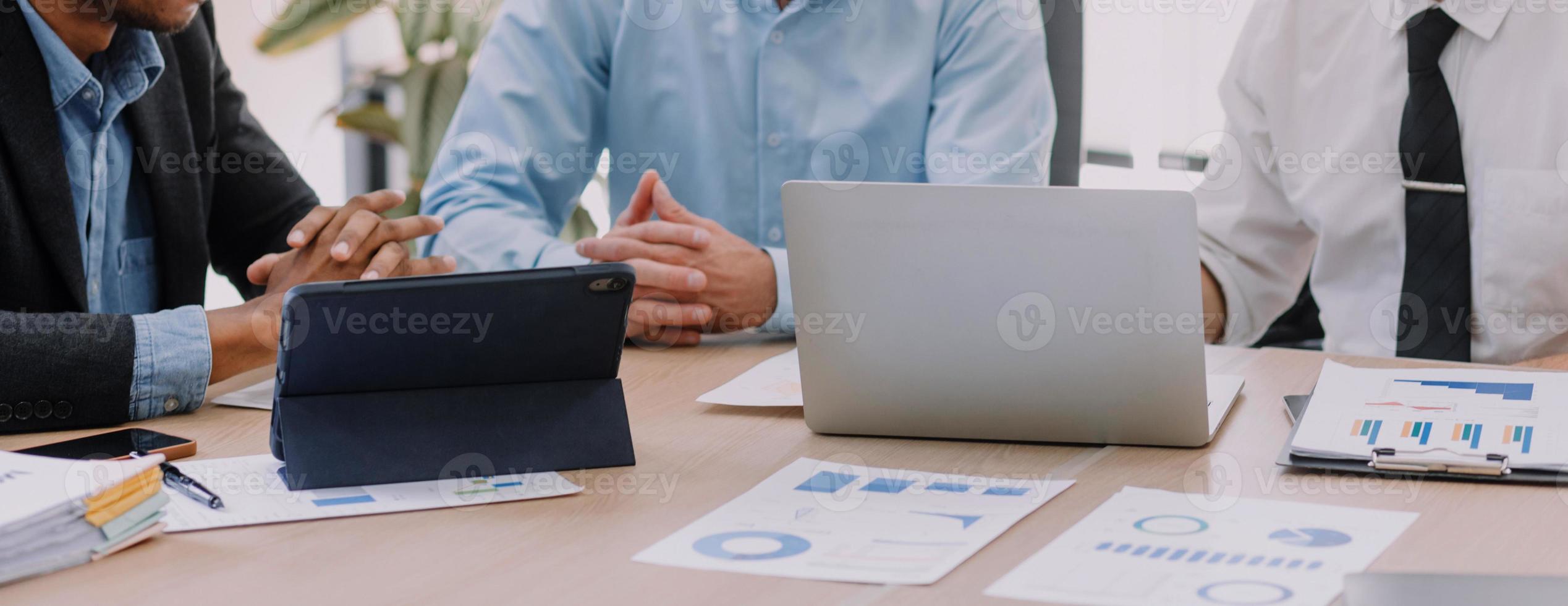 Financial analysts analyze business financial reports on a digital tablet planning investment project during a discussion at a meeting of corporate showing the results of their successful teamwork. photo