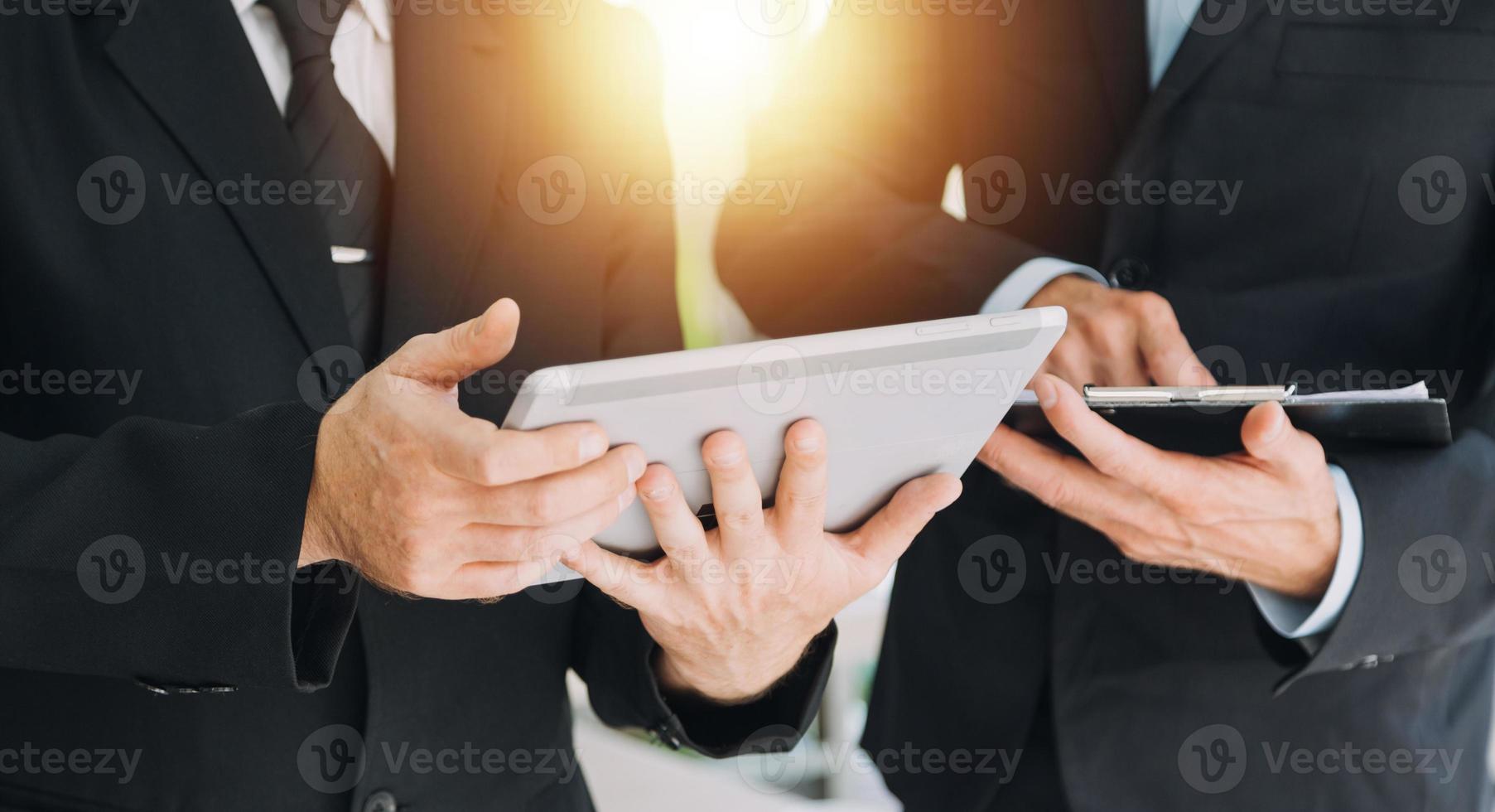 Financial analysts analyze business financial reports on a digital tablet planning investment project during a discussion at a meeting of corporate showing the results of their successful teamwork. photo