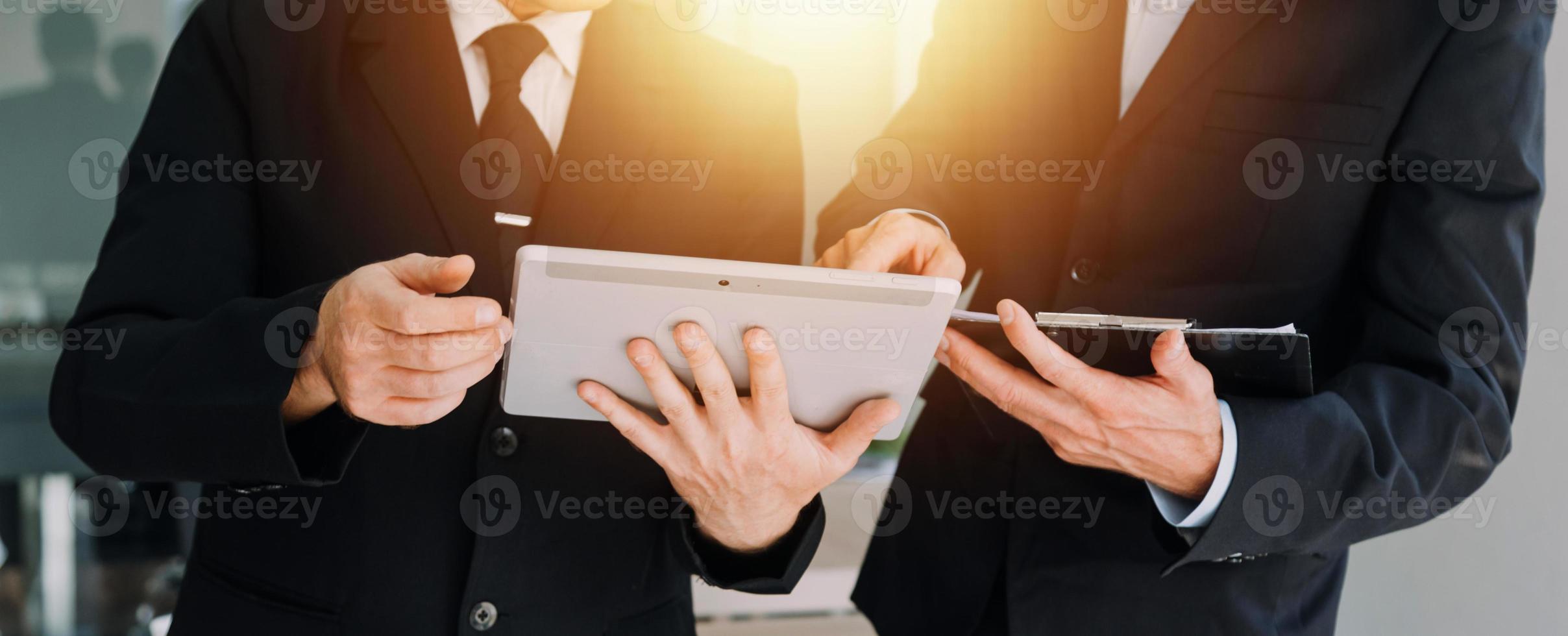 Financial analysts analyze business financial reports on a digital tablet planning investment project during a discussion at a meeting of corporate showing the results of their successful teamwork. photo