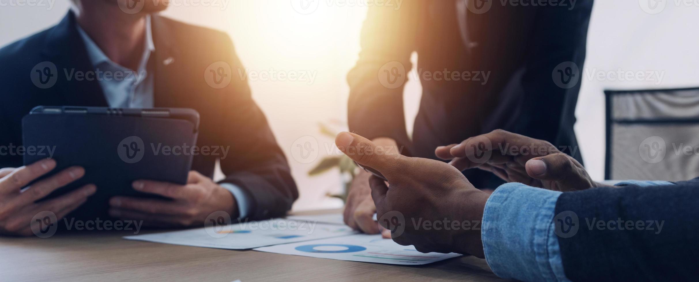 Financial analysts analyze business financial reports on a digital tablet planning investment project during a discussion at a meeting of corporate showing the results of their successful teamwork. photo