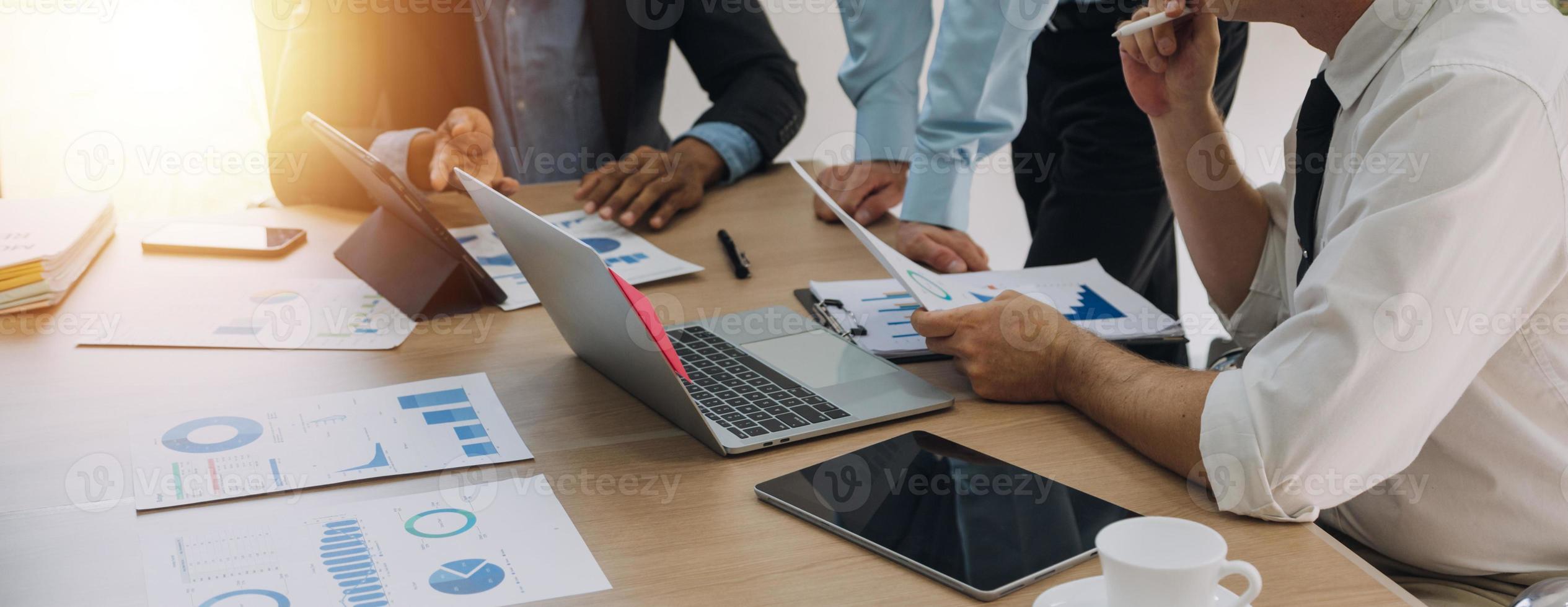 Financial analysts analyze business financial reports on a digital tablet planning investment project during a discussion at a meeting of corporate showing the results of their successful teamwork. photo