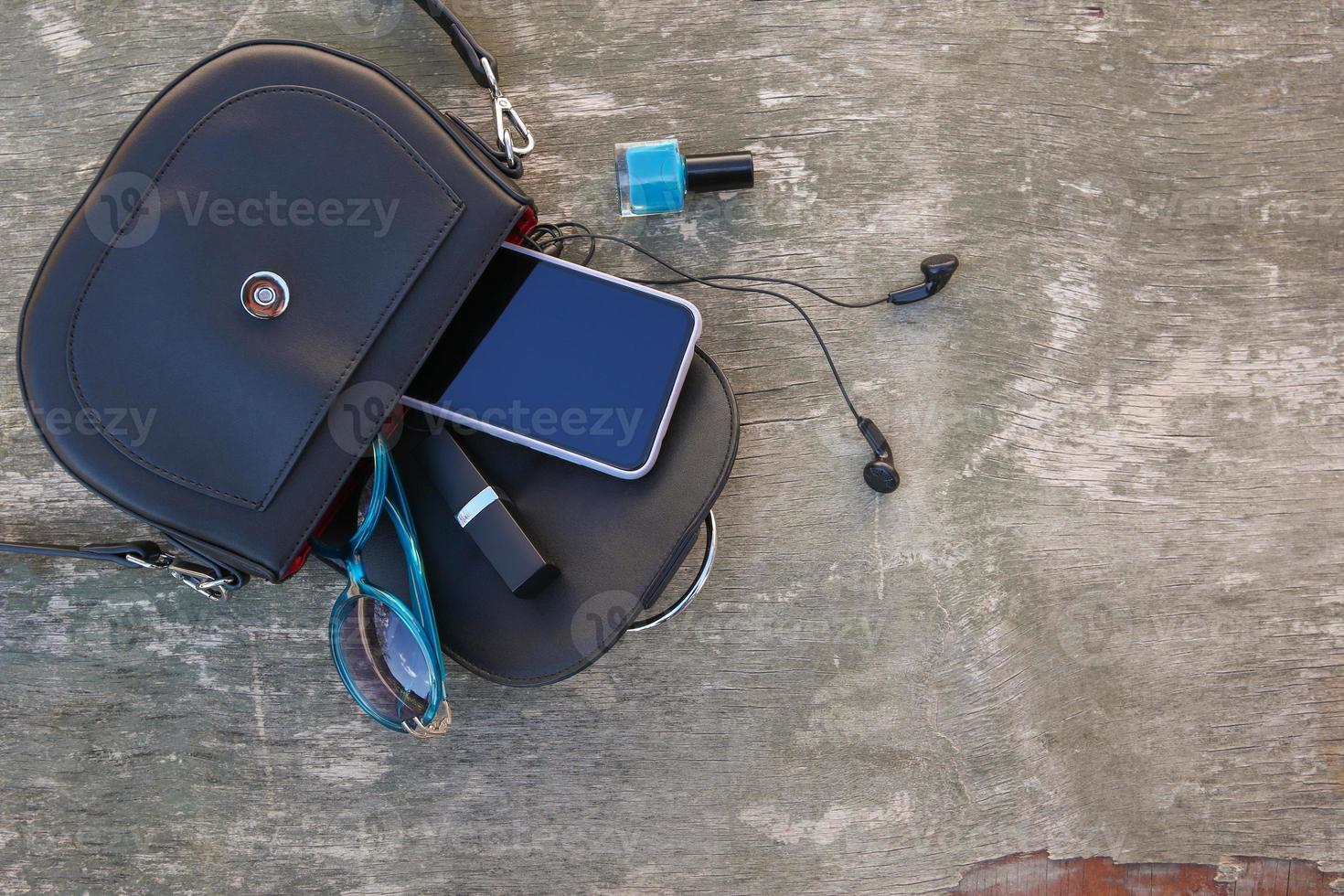 Things from open lady purse. Cosmetics and women's accessories fell out of blue handbag. Top view. photo