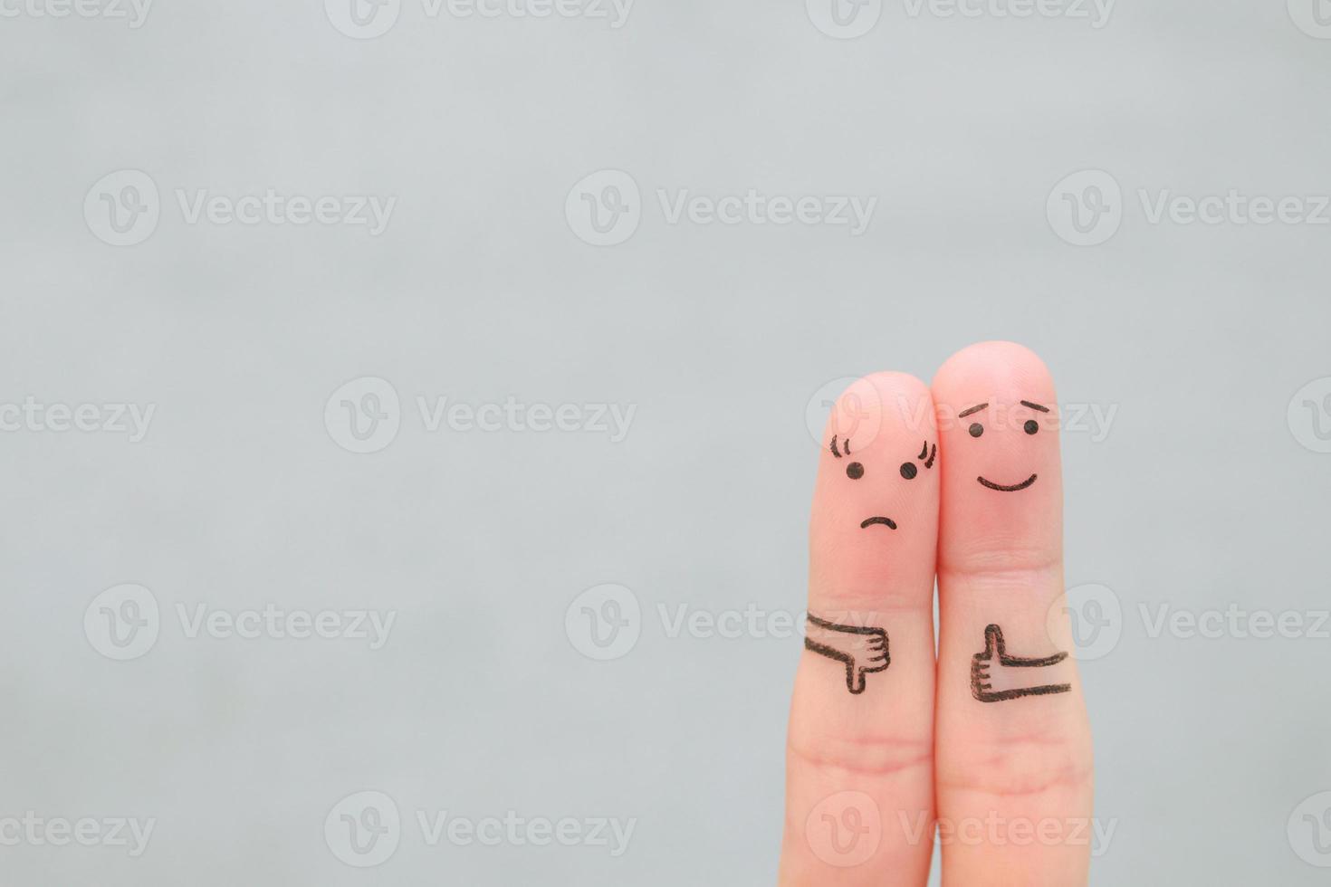 Fingers art of couple. Woman showing thumb down and man showing thumb up. Concept of disagreement in family. photo