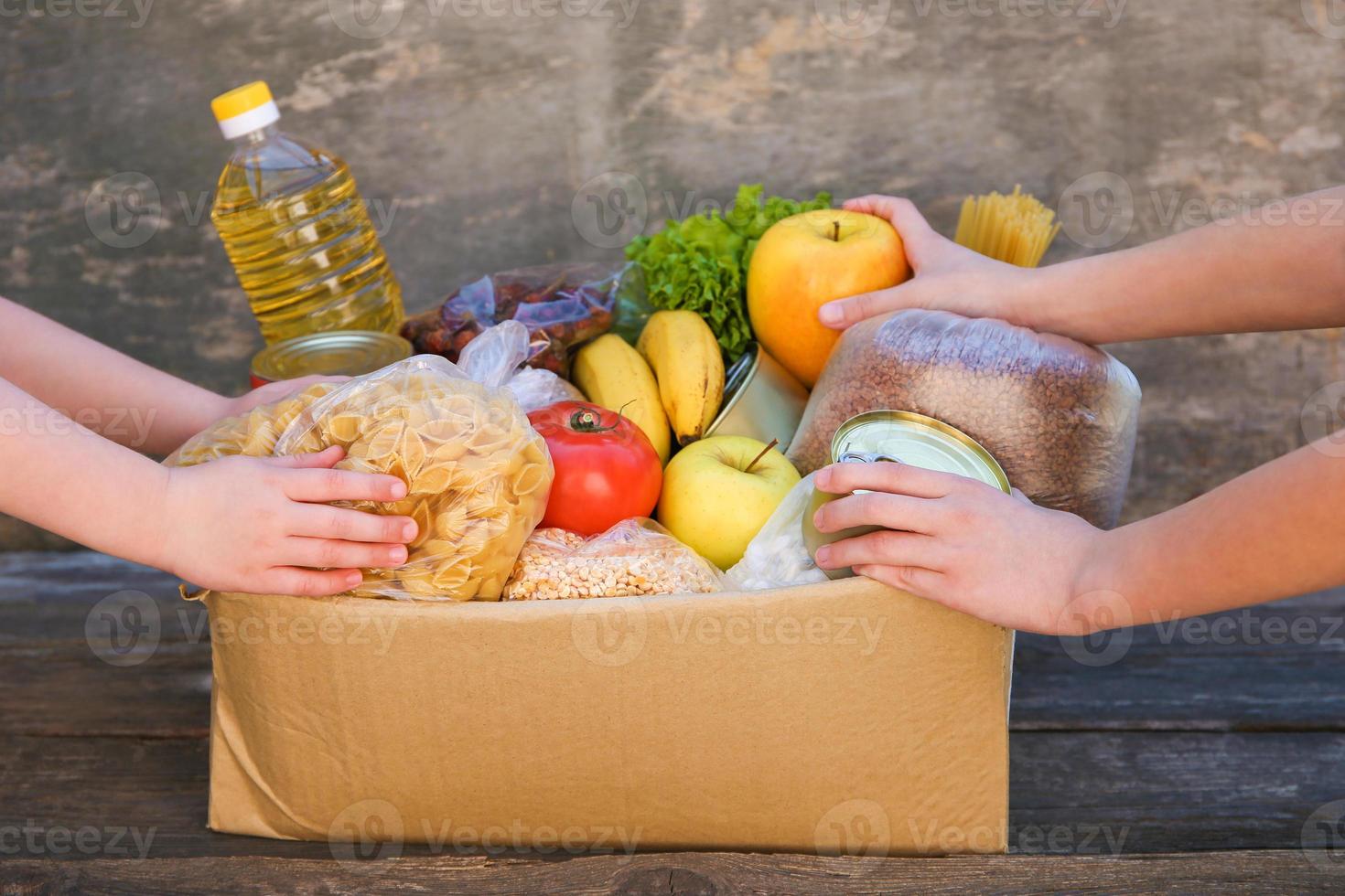 Donation box with food on old wooden background. photo