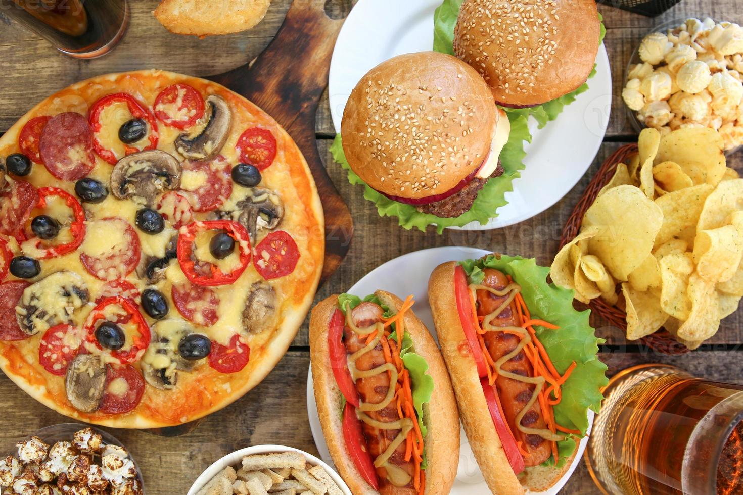 Fast food on old wooden background. Concept of junk eating. Top view. Flat lay. photo