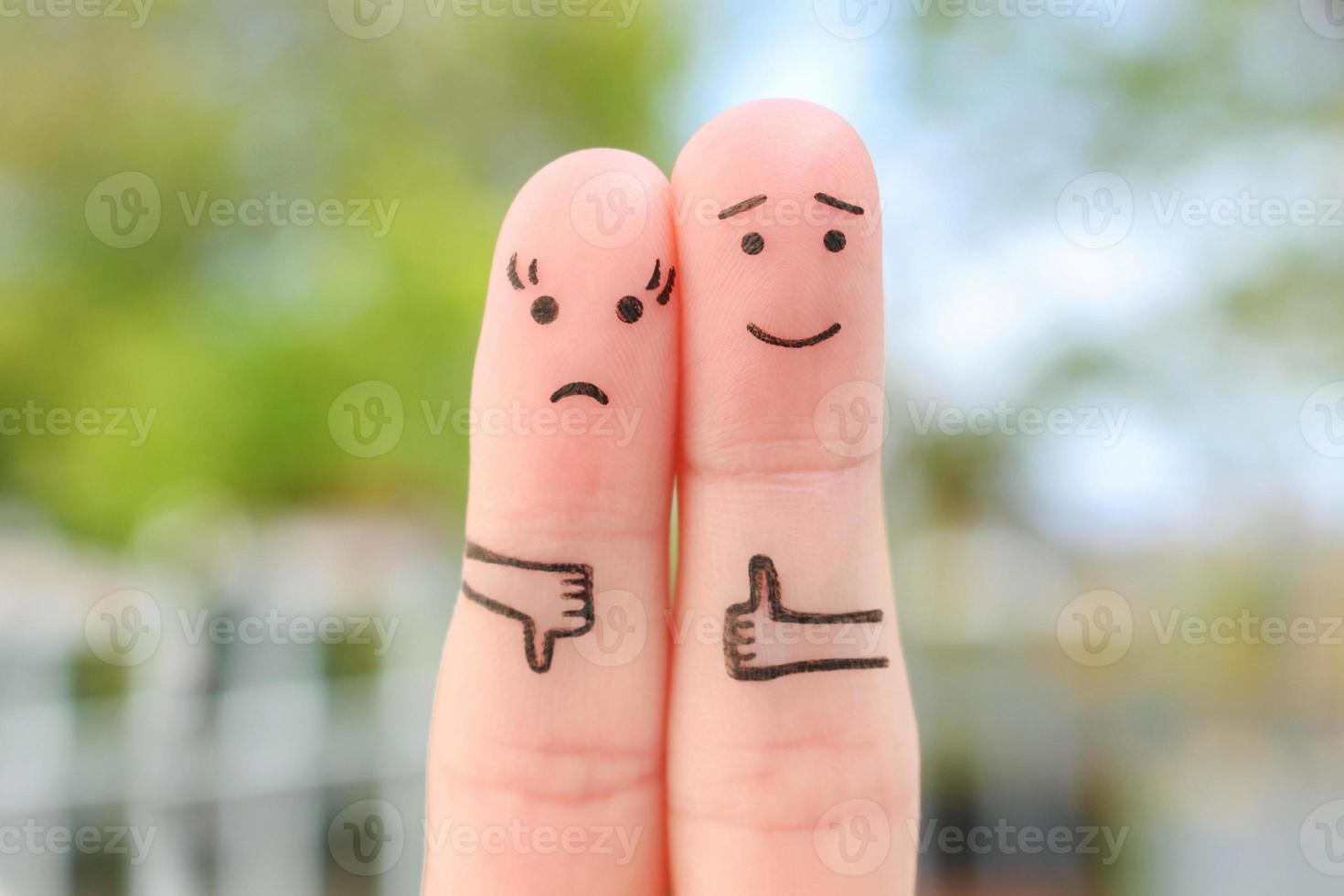 Fingers art of couple. Woman showing thumb down and man showing thumb up. Concept of disagreement in family. photo