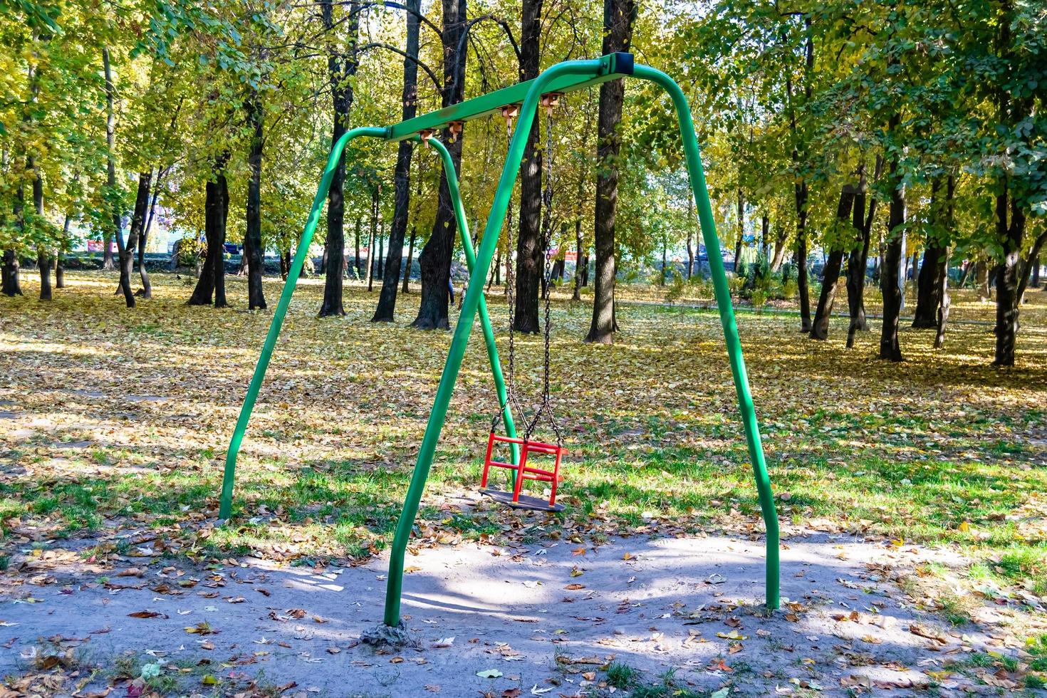 fotografía sobre el tema patio de juegos vacío con columpio de metal para niños foto