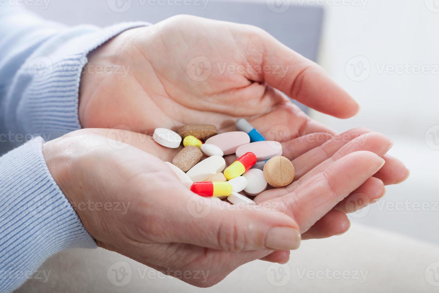 Many pills in woman hands. closeup on white background, macro selective focus. photo