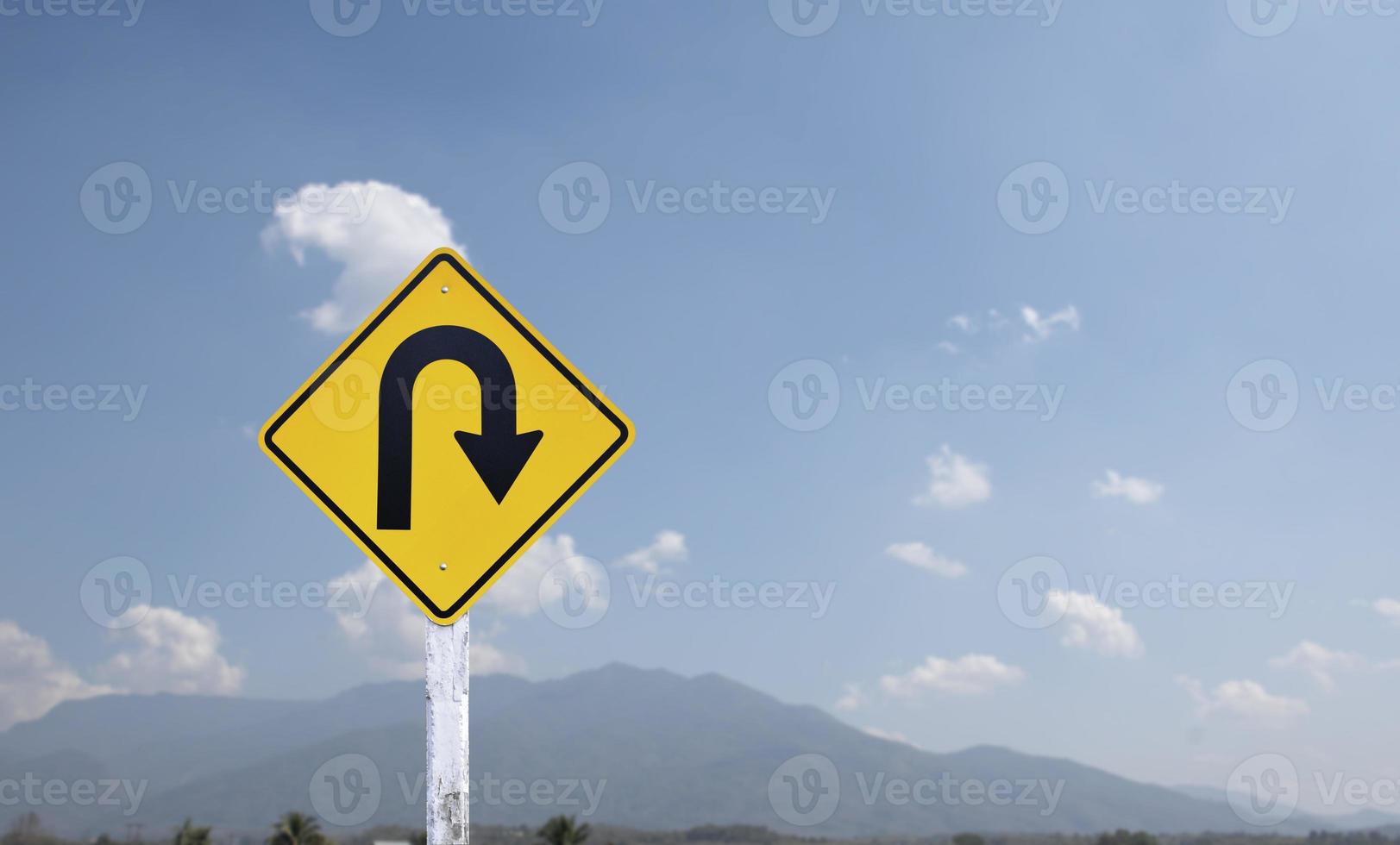 señal de tráfico, señal de giro a la derecha en el poste de cemento al lado de la carretera rural con fondo de cielo azul nublado blanco, espacio de copia. foto