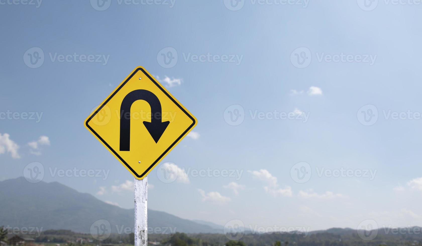 señal de tráfico, señal de giro a la derecha en el poste de cemento al lado de la carretera rural con fondo de cielo azul nublado blanco, espacio de copia. foto