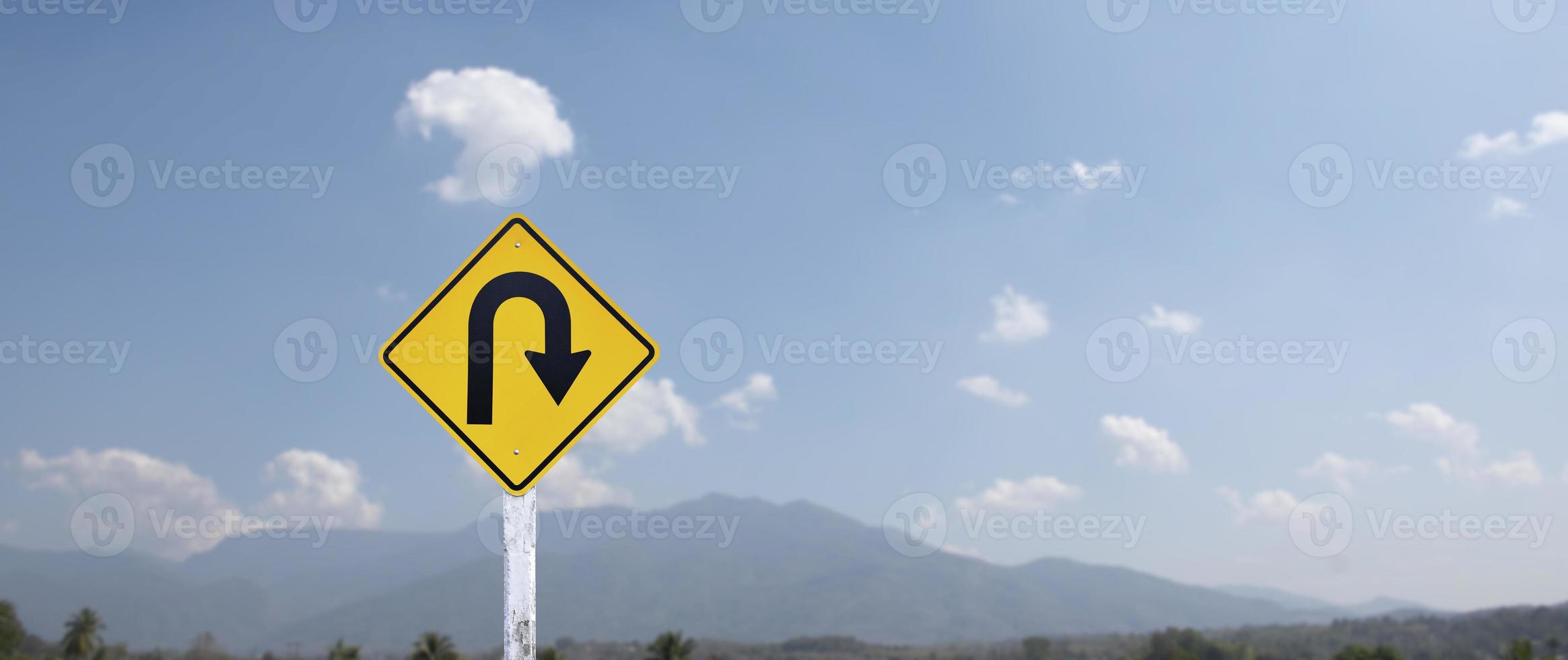 señal de tráfico, señal de giro a la derecha en el poste de cemento al lado de la carretera rural con fondo de cielo azul nublado blanco, espacio de copia. foto