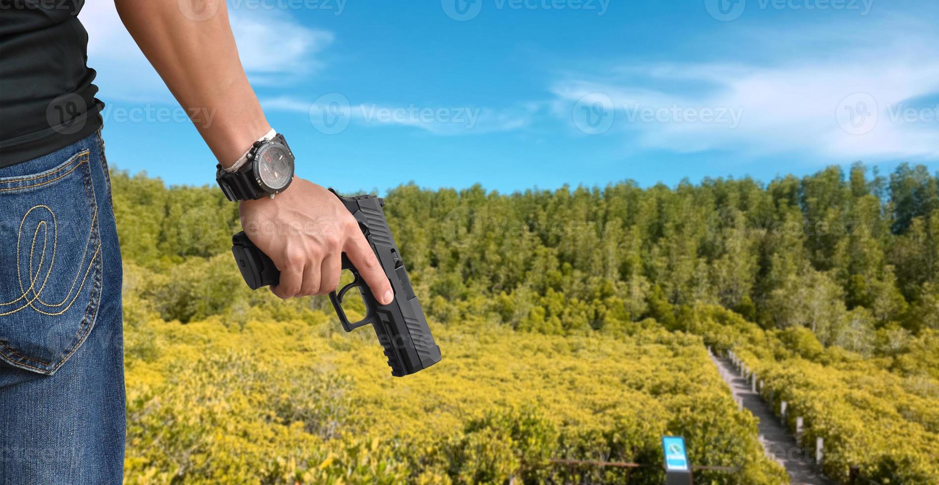 Pistola automática de 9 mm sujeta en la mano derecha del tirador, concepto de seguridad, robo, gángster, guardaespaldas en todo el mundo. enfoque selectivo en pistola. foto