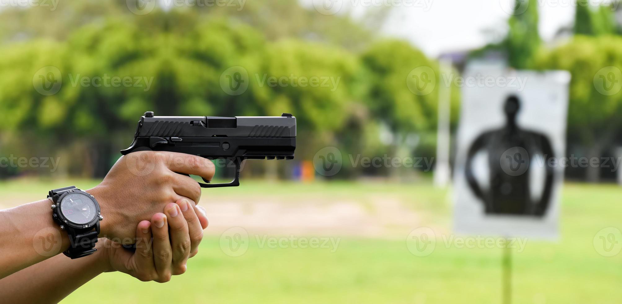 Pistola automática de 9 mm sujeta en la mano derecha del tirador, concepto de seguridad, robo, gángster, guardaespaldas en todo el mundo. enfoque selectivo en pistola. foto