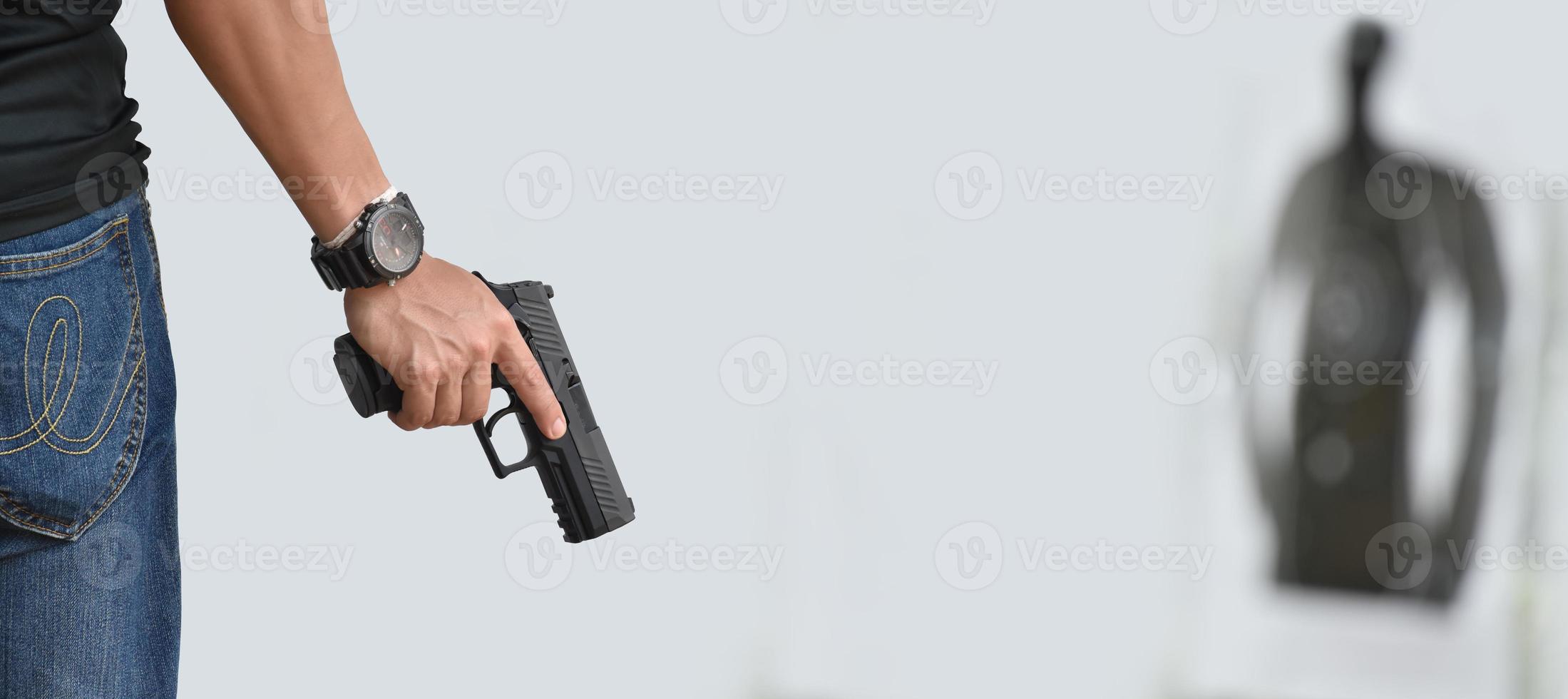 Pistola automática de 9 mm sujeta en la mano derecha del tirador, concepto de seguridad, robo, gángster, guardaespaldas en todo el mundo. enfoque selectivo en pistola. foto