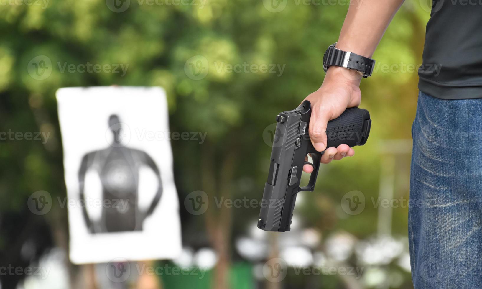 9mm automatic pistol holding in right hand of shooter, concept for security, robbery, gangster, bodyguard around the world. selective focus on pistol. photo