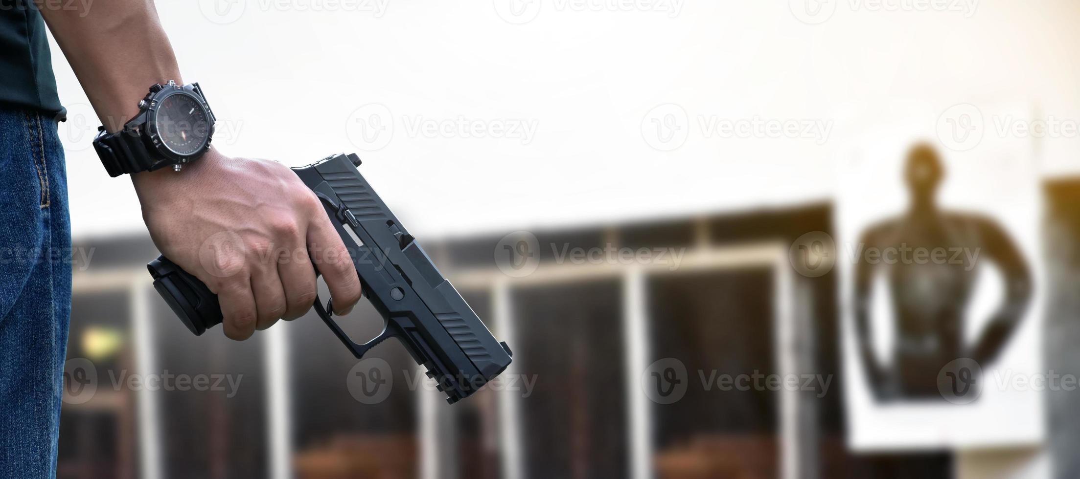 Pistola automática de 9 mm sujeta en la mano derecha del tirador, concepto de seguridad, robo, gángster, guardaespaldas en todo el mundo. enfoque selectivo en pistola. foto