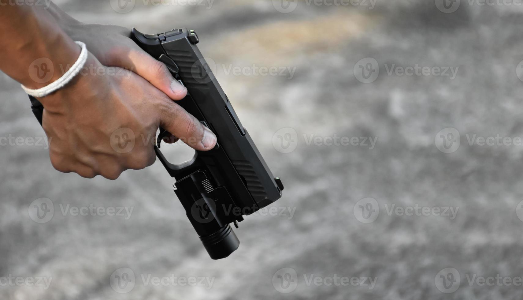 9mm automatic pistol holding in right hand of shooter, concept for security, robbery, gangster, bodyguard around the world. selective focus on pistol. photo