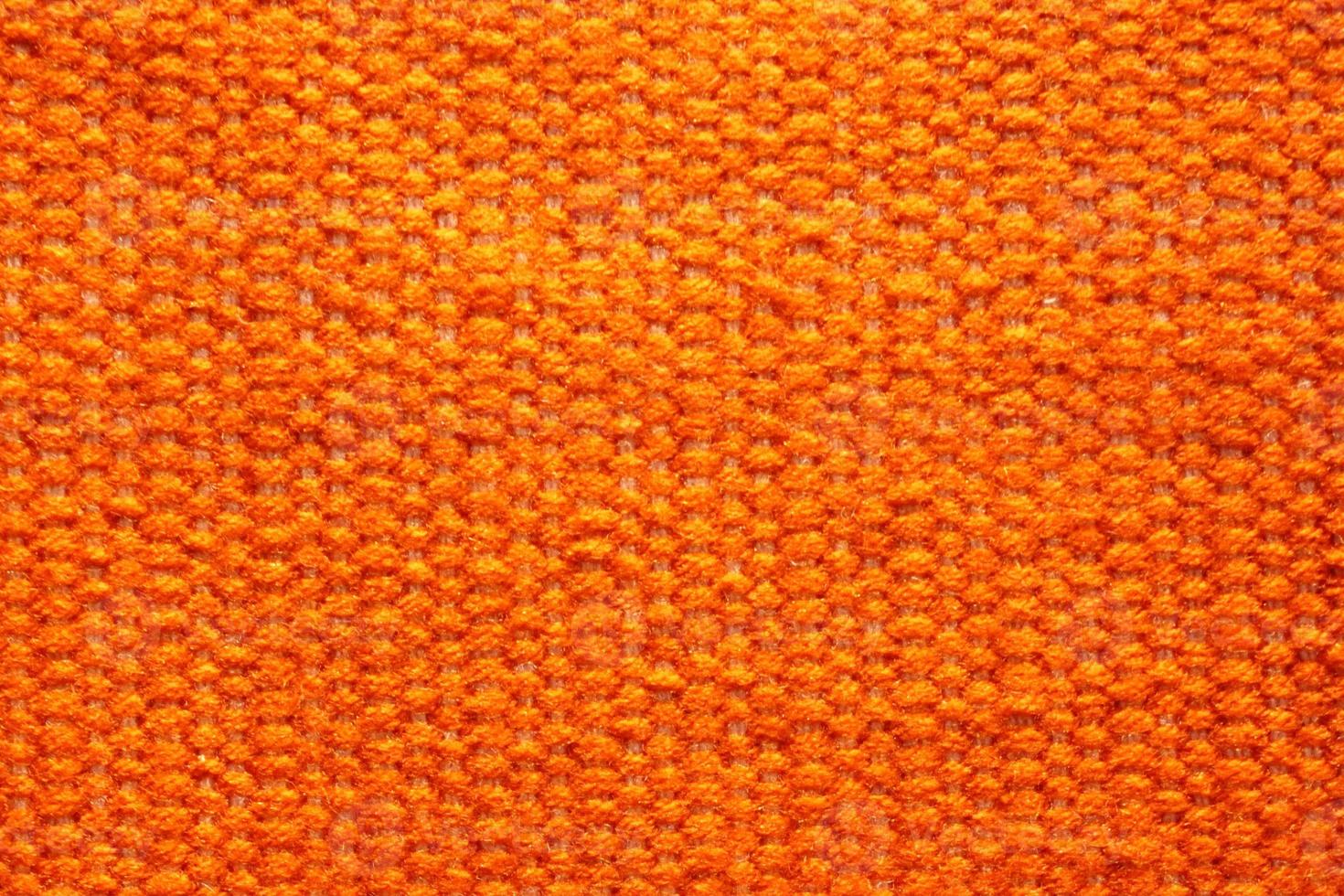 Woven orange wool fabric texture. Hand knitted textile canvas background. Patchwork carpet backdrop. Factory material threads. Abstract design. Close-up, mockup, top view photo