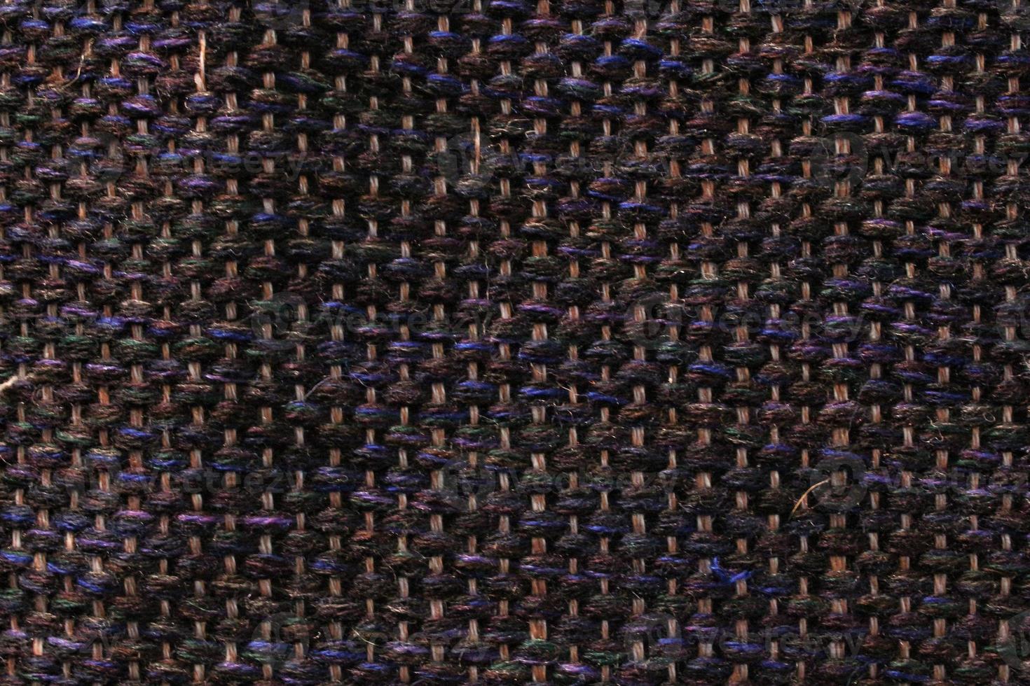 Woven dark wool fabric texture. Hand knitted textile canvas background. Patchwork carpet backdrop. Factory material threads. Abstract design. Close-up, mockup, top view photo