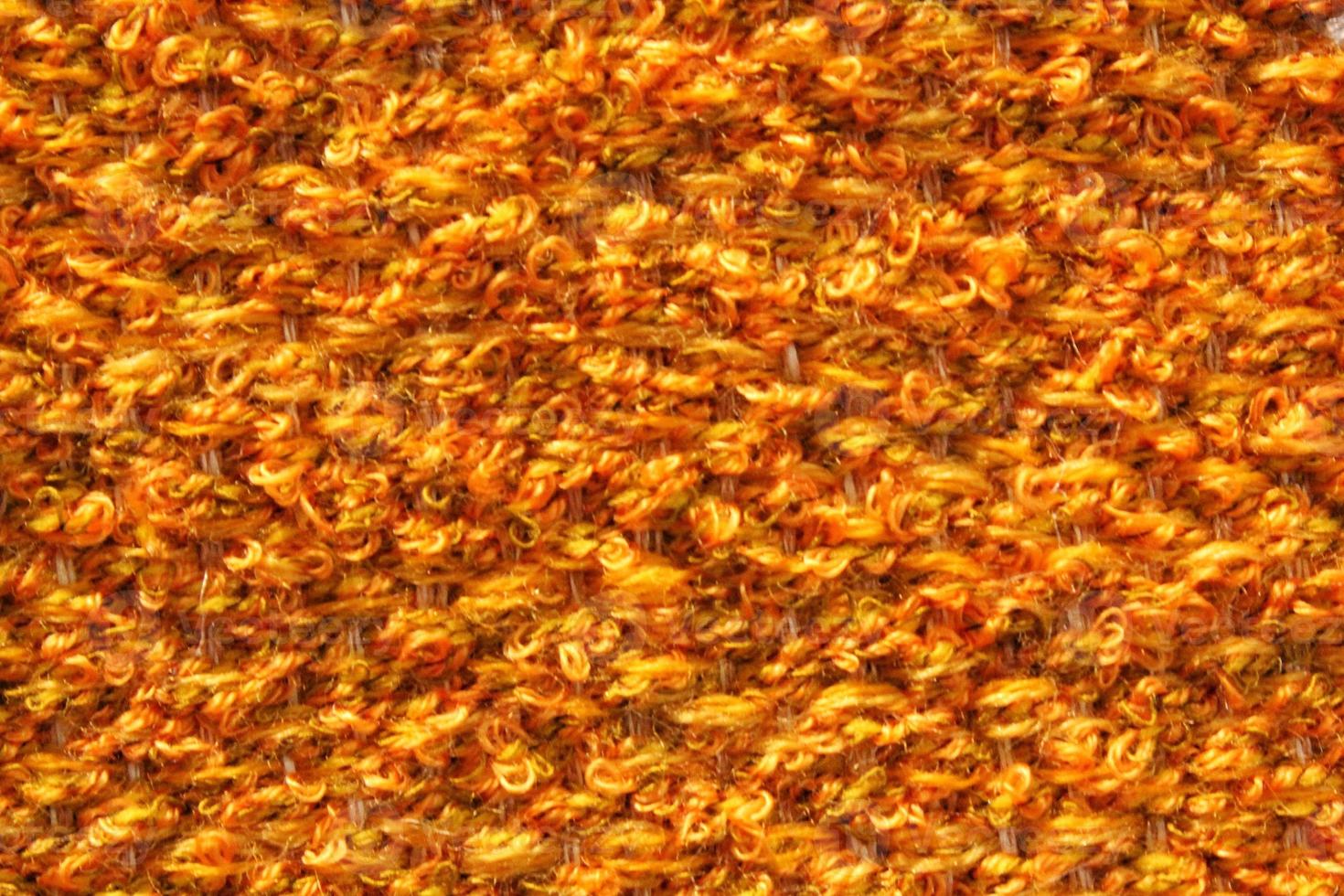 Woven orange wool fabric texture. Hand knitted textile canvas background. Patchwork carpet backdrop. Factory material threads. Abstract design. Close-up, mockup, top view photo