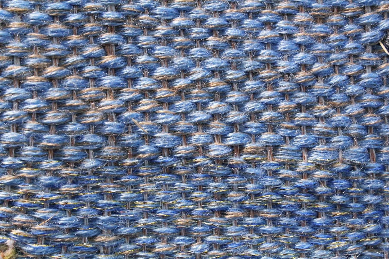 Woven blue wool fabric texture. Hand knitted textile canvas background. Patchwork carpet backdrop. Factory material threads. Abstract design. Close-up, mockup, top view photo