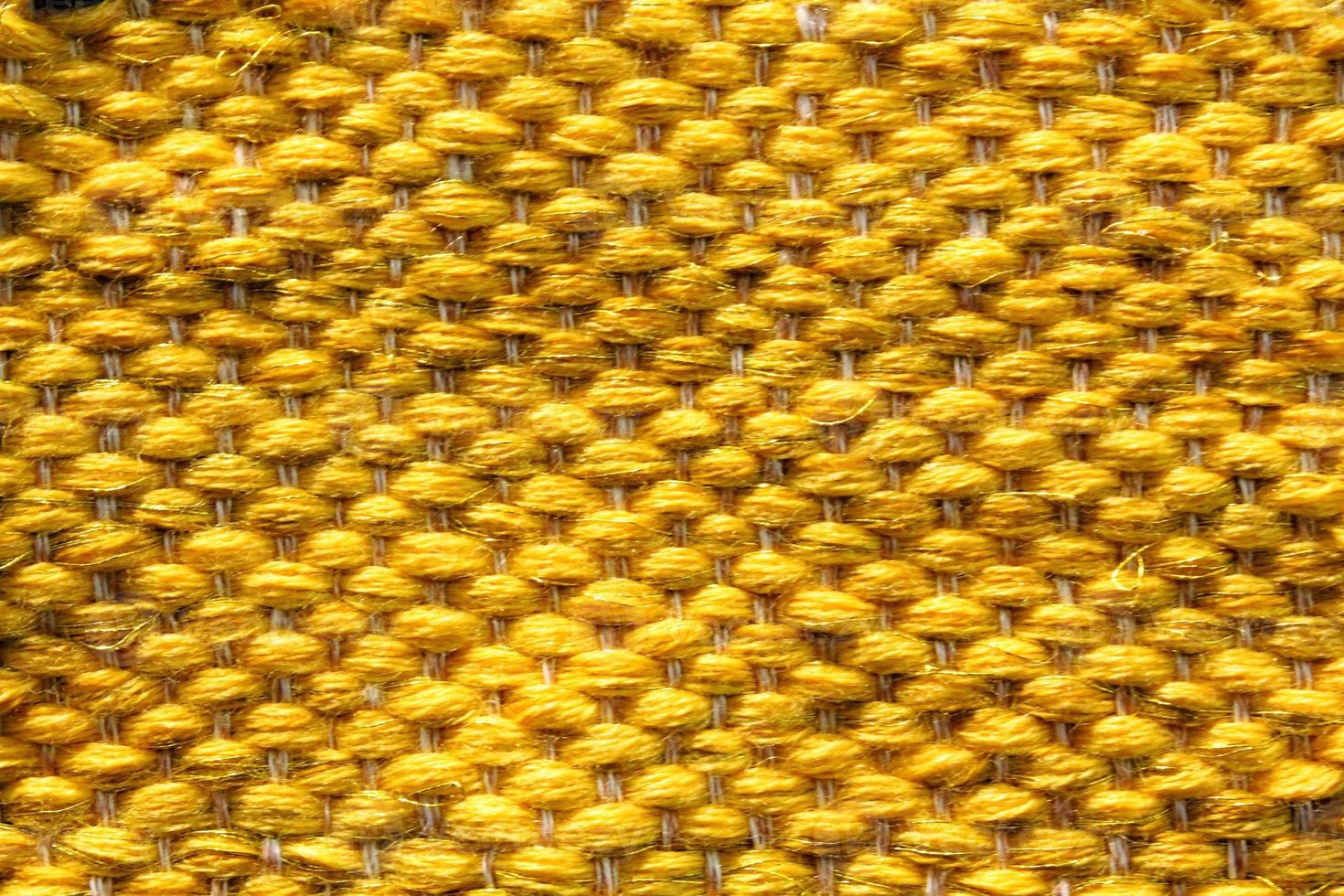 Woven yellow wool fabric texture. Hand knitted textile canvas background. Patchwork carpet backdrop. Factory material threads. Abstract design. Close-up, mockup, top view photo