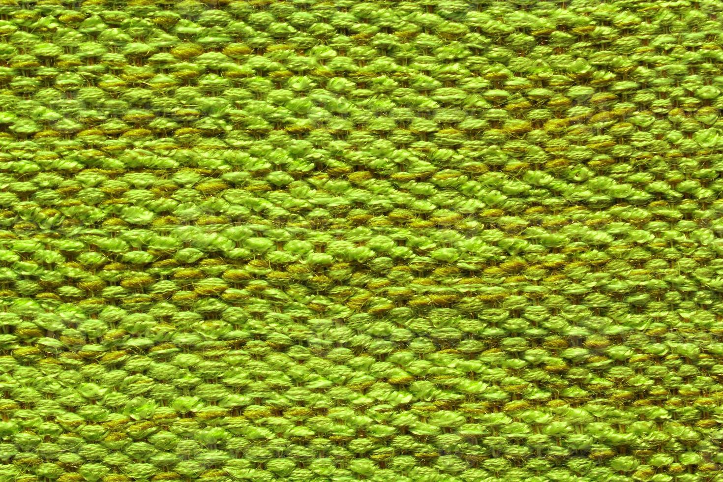 Woven green wool fabric texture. Hand knitted textile canvas background. Patchwork carpet backdrop. Factory material threads. Abstract design. Close-up, mockup, top view photo