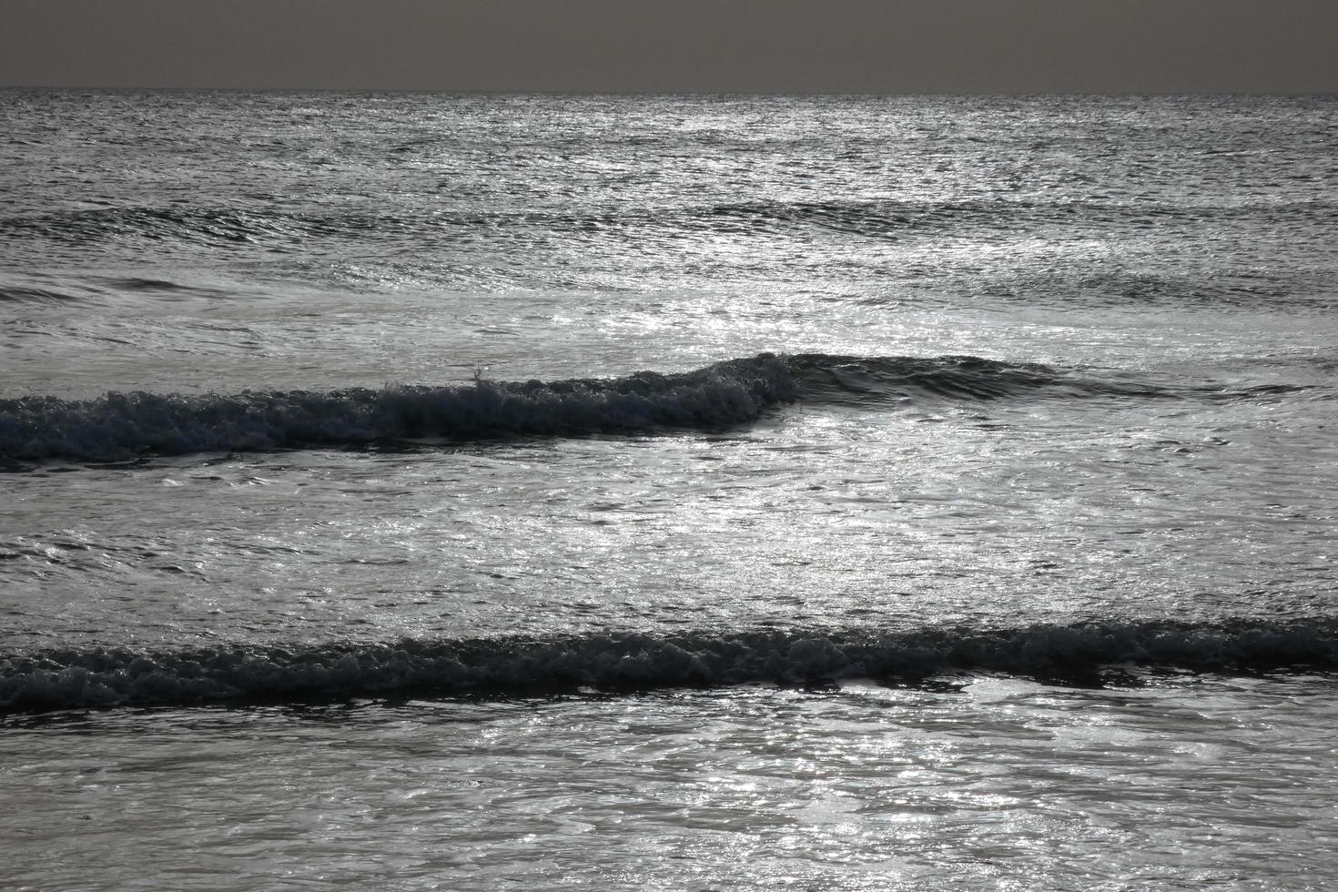 lonely, uncrowded beach with calm sea and small waves photo
