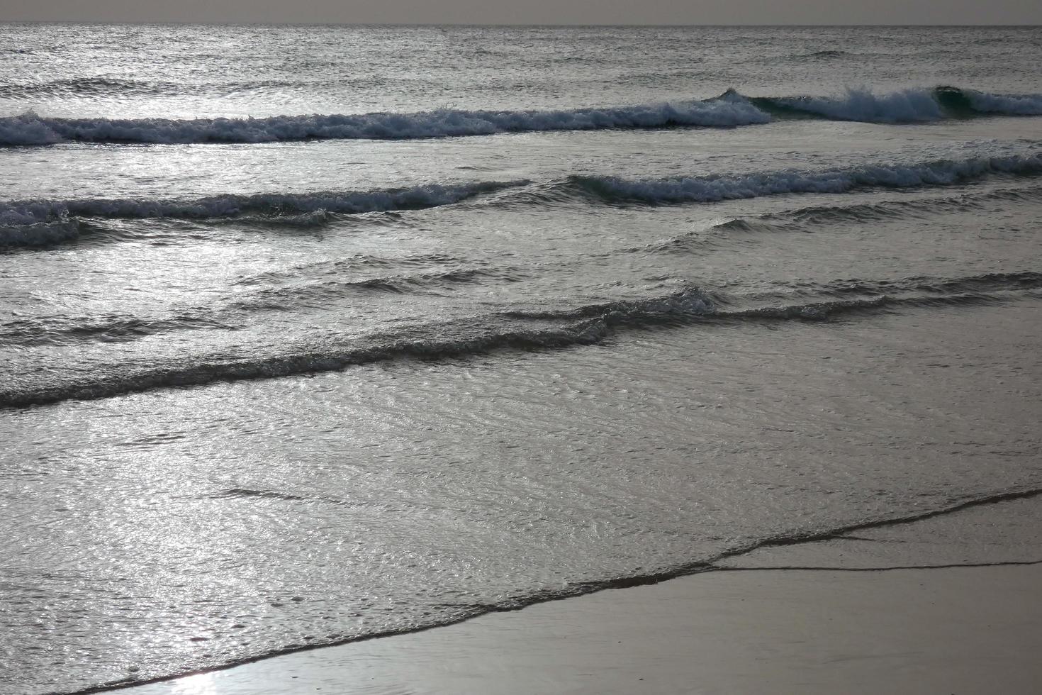 lonely, uncrowded beach with calm sea and small waves photo