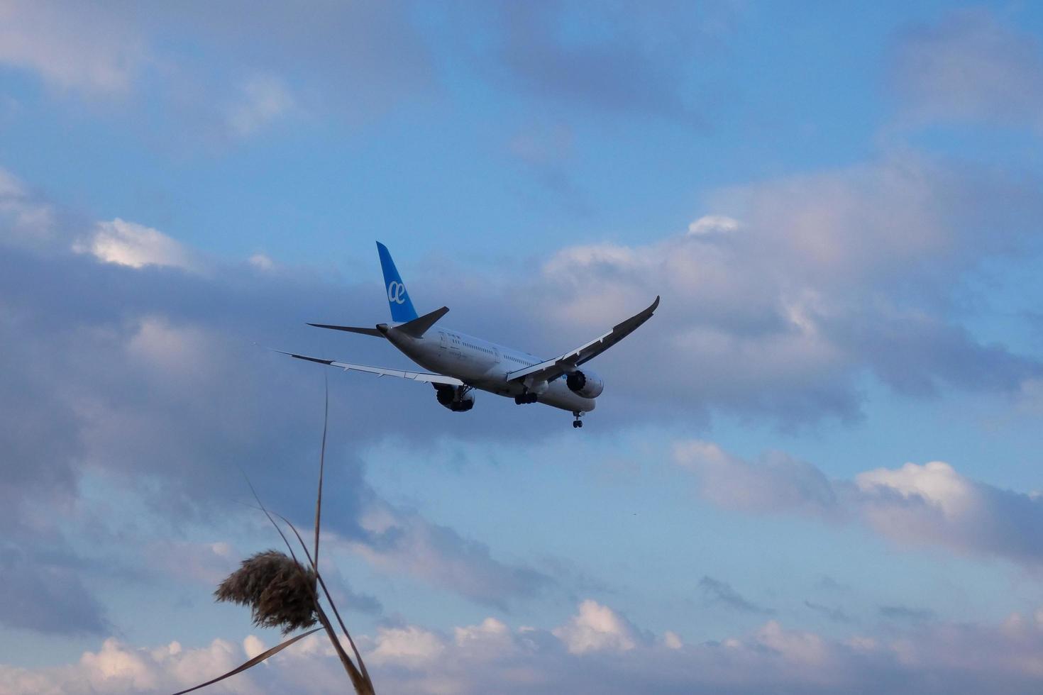 Commercial aircraft overflying the sky and arriving at airport photo