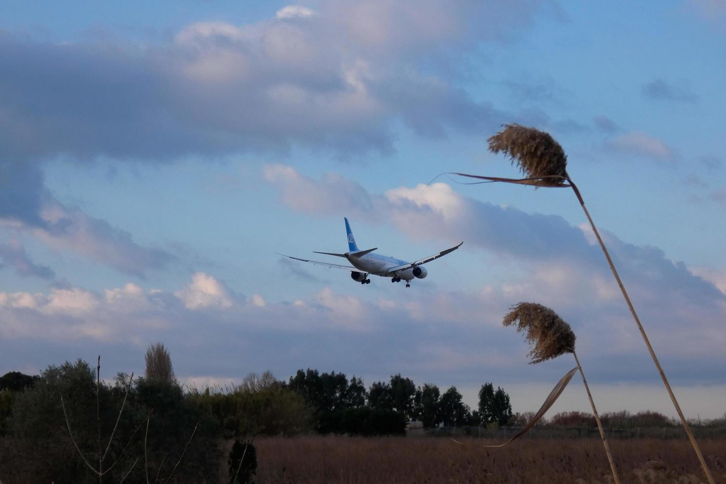 Commercial aircraft overflying the sky and arriving at airport photo