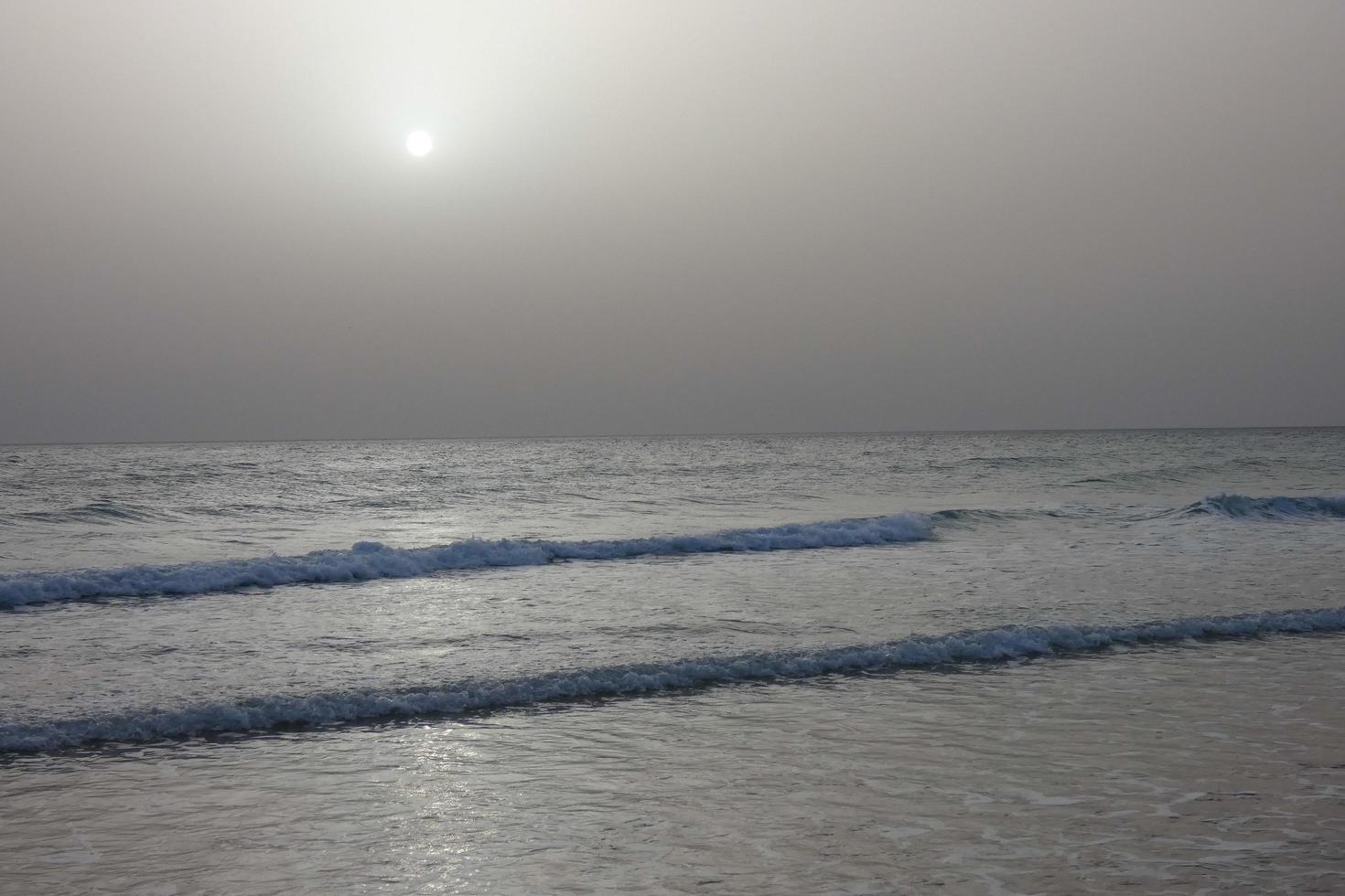 lonely, uncrowded beach with calm sea and small waves photo