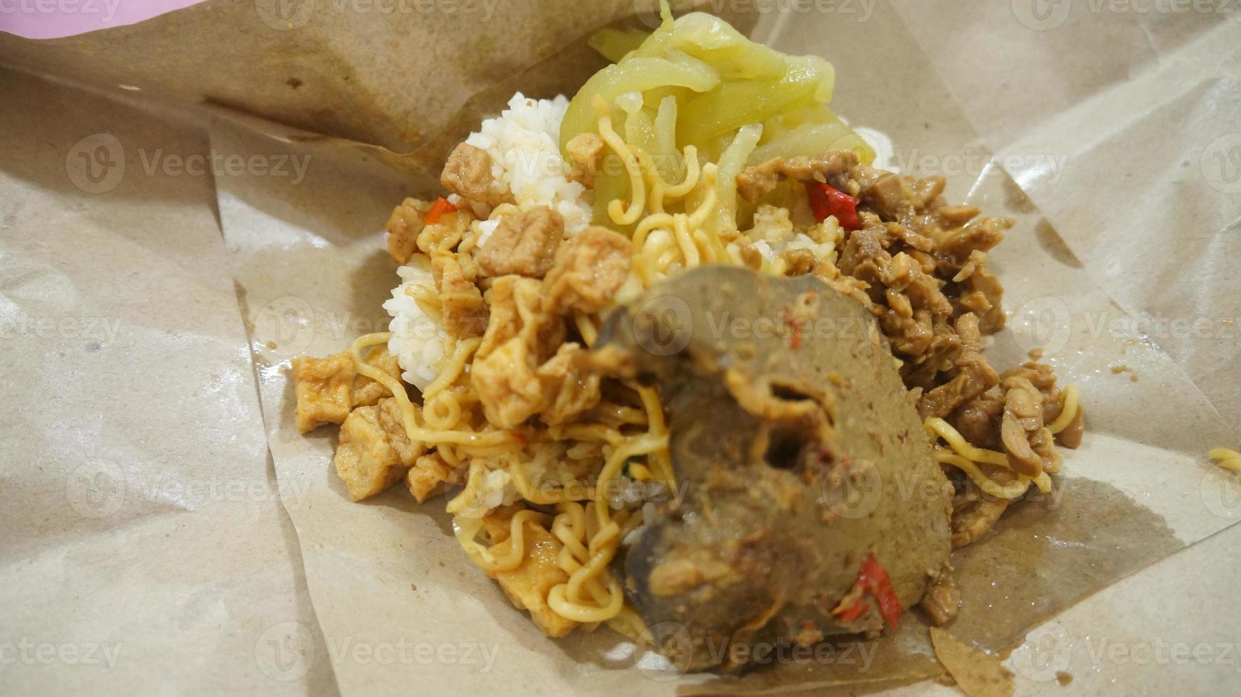Nasi kucing special, cat rice special with opor hati sapi on a paper wrap photo