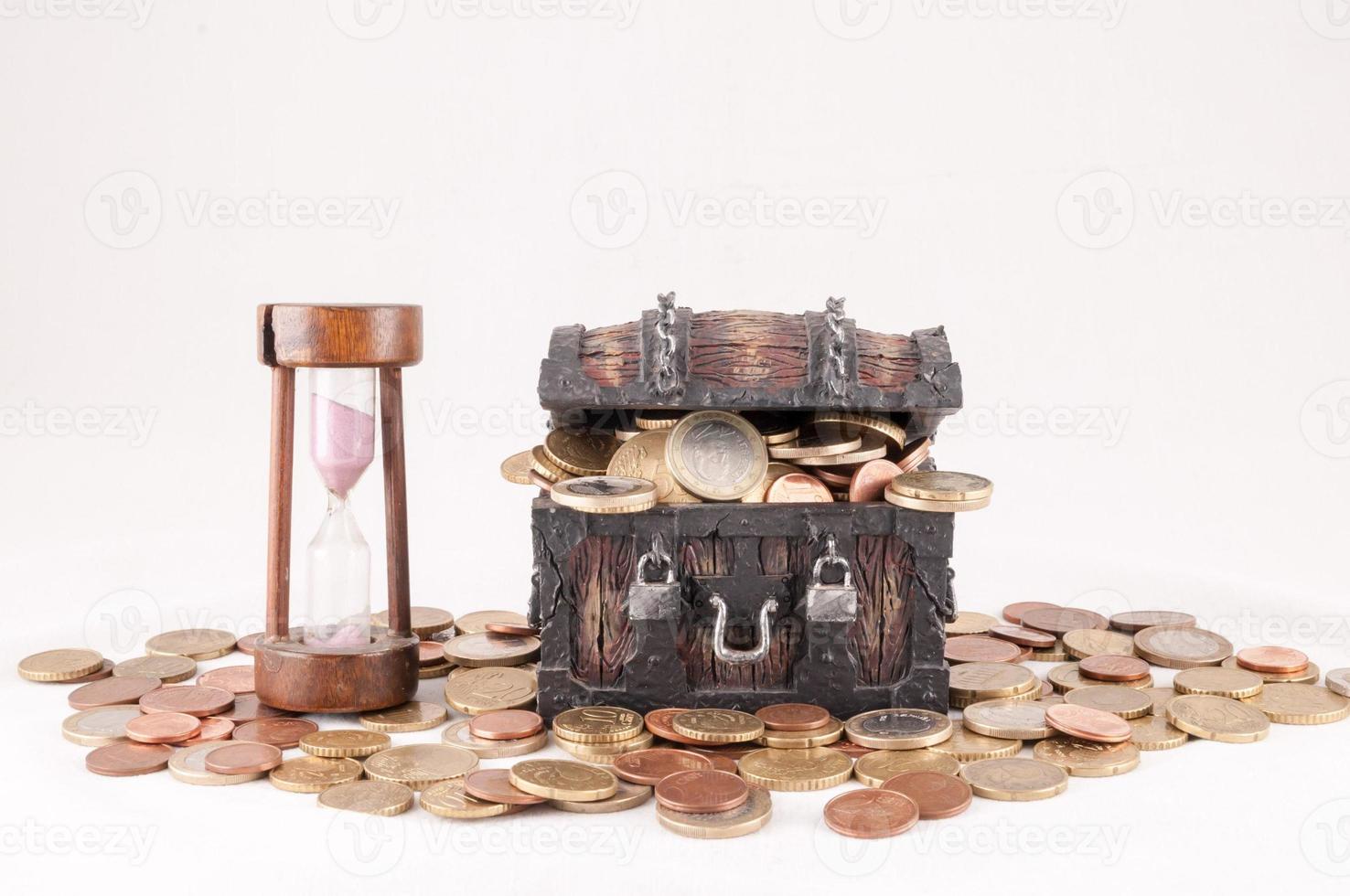 Hourglass and treasure chest isolated on white background photo