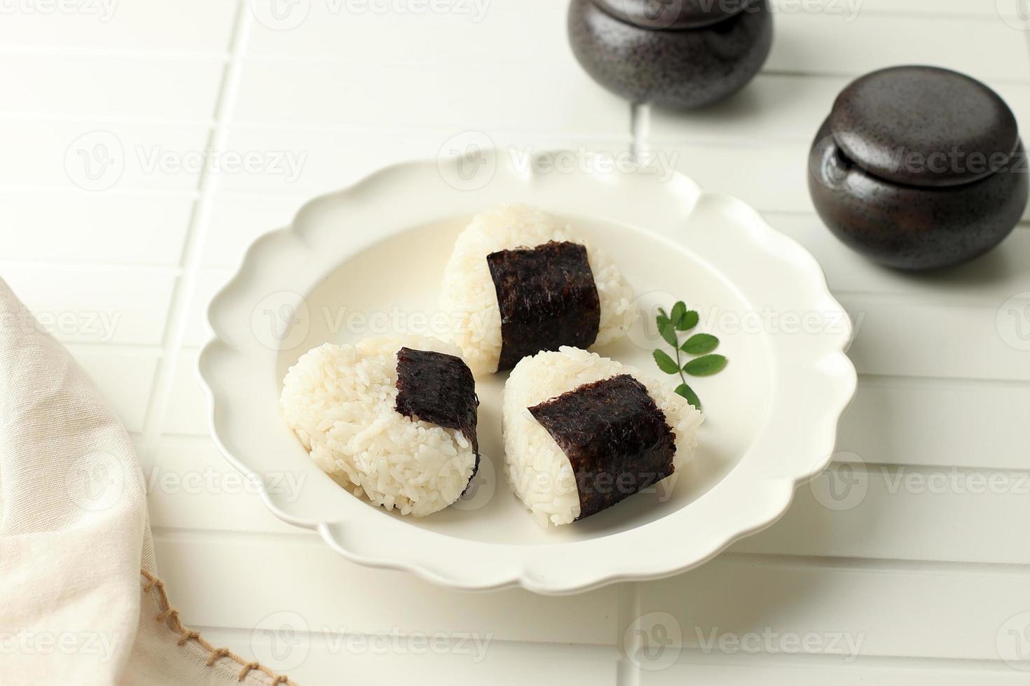 Onigiri. Rice Triangle with Nori Seaweed on White Plate. photo