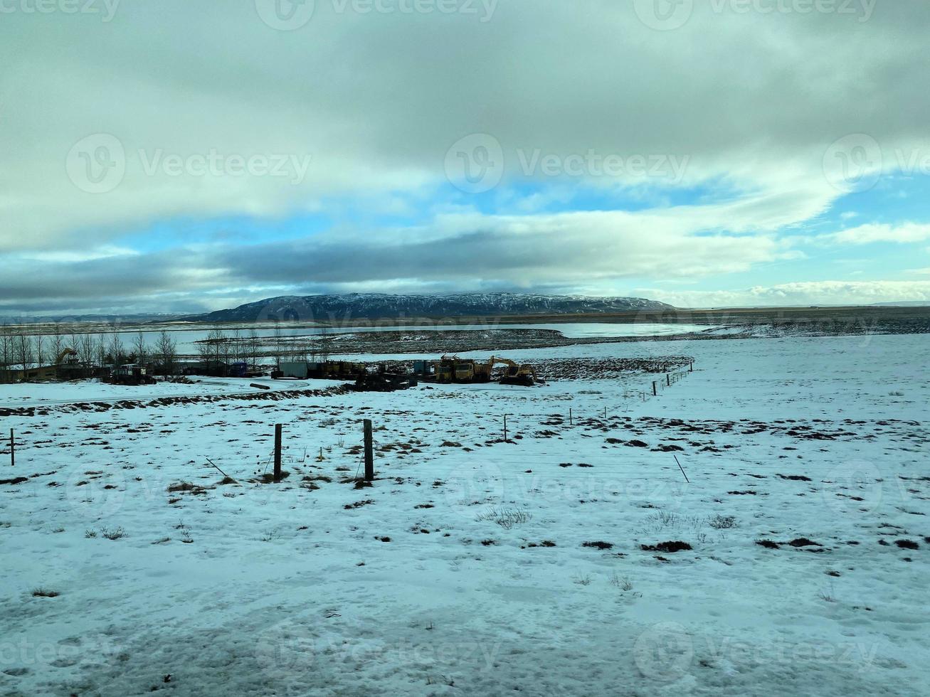 Icelandic winter landscape with snow covered hills and blue cloudy sky photo