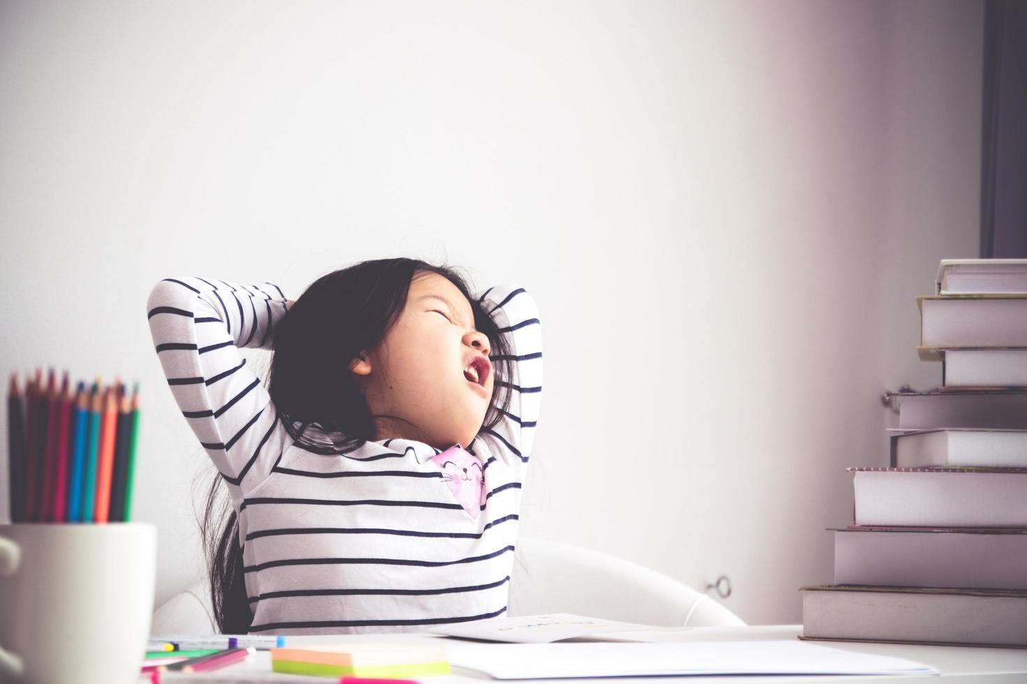 pequeño niña con largo pelo linda ella actuó aburrido de estudiando, lectura, sensación no divertida. concepto de niño educación desarrollo foto